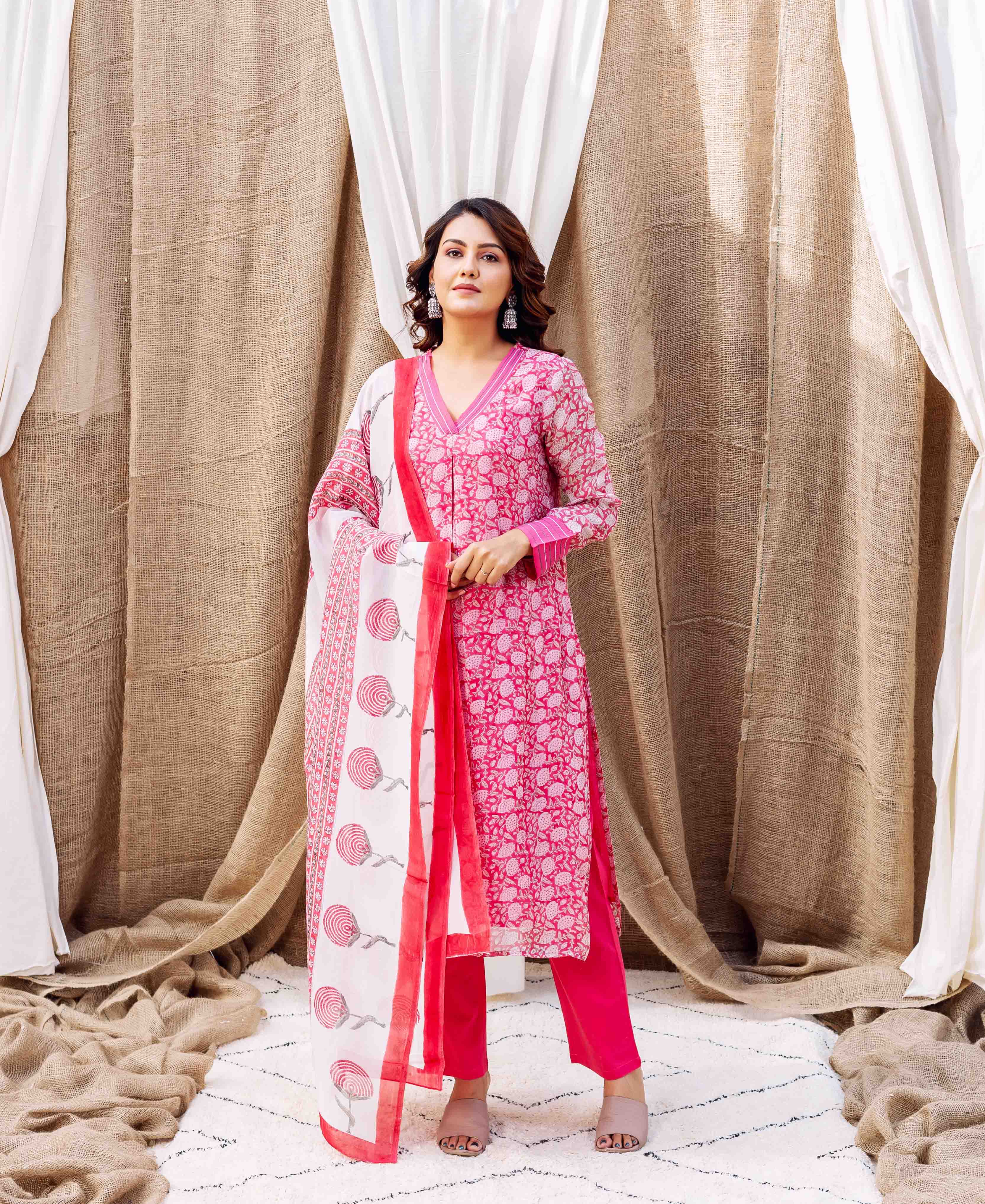 Full-length model in pink hand-block printed floral kurta set with white dupatta.
