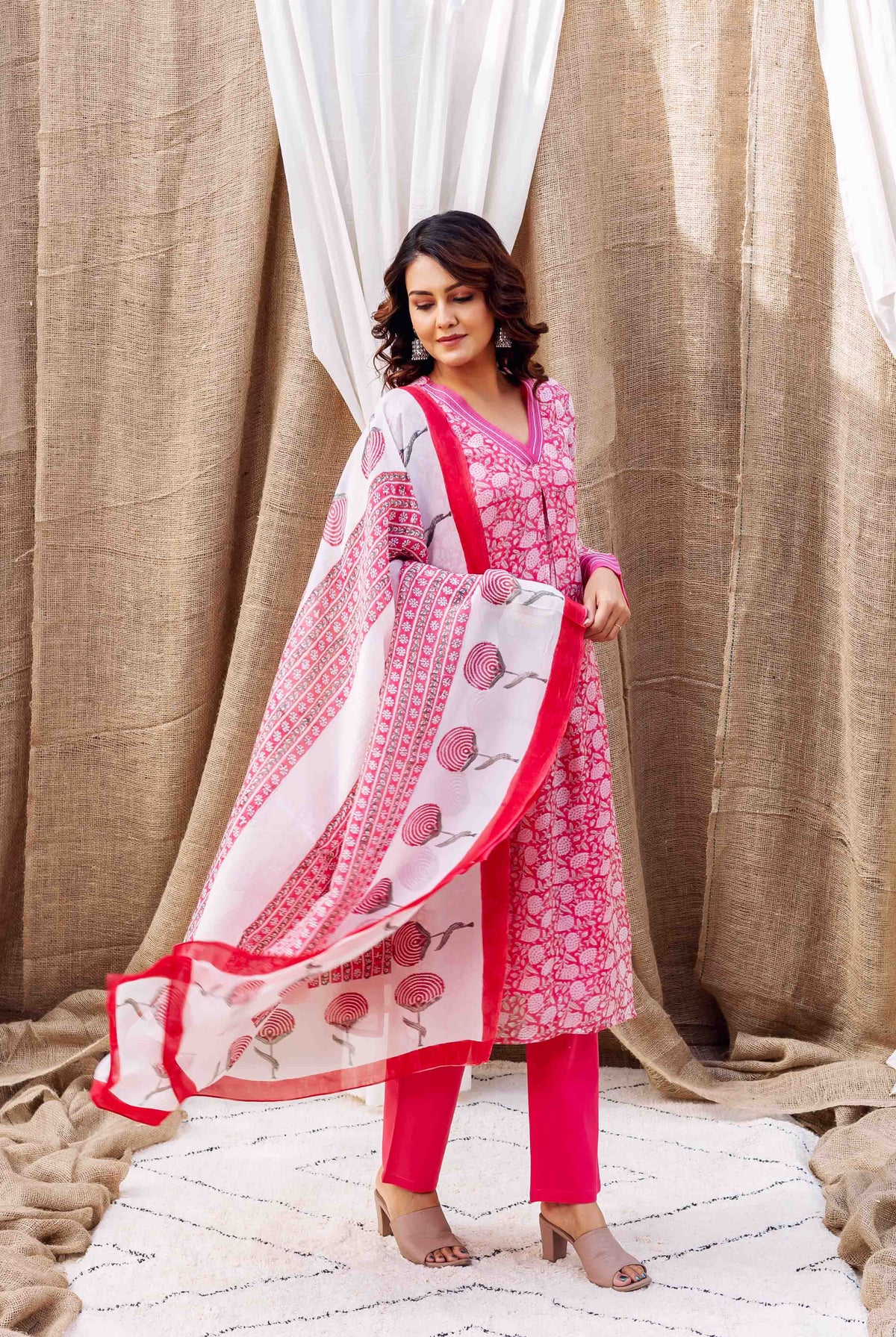 Full shot of model in pink hand-block-printed kurta set with white flowing dupatta.