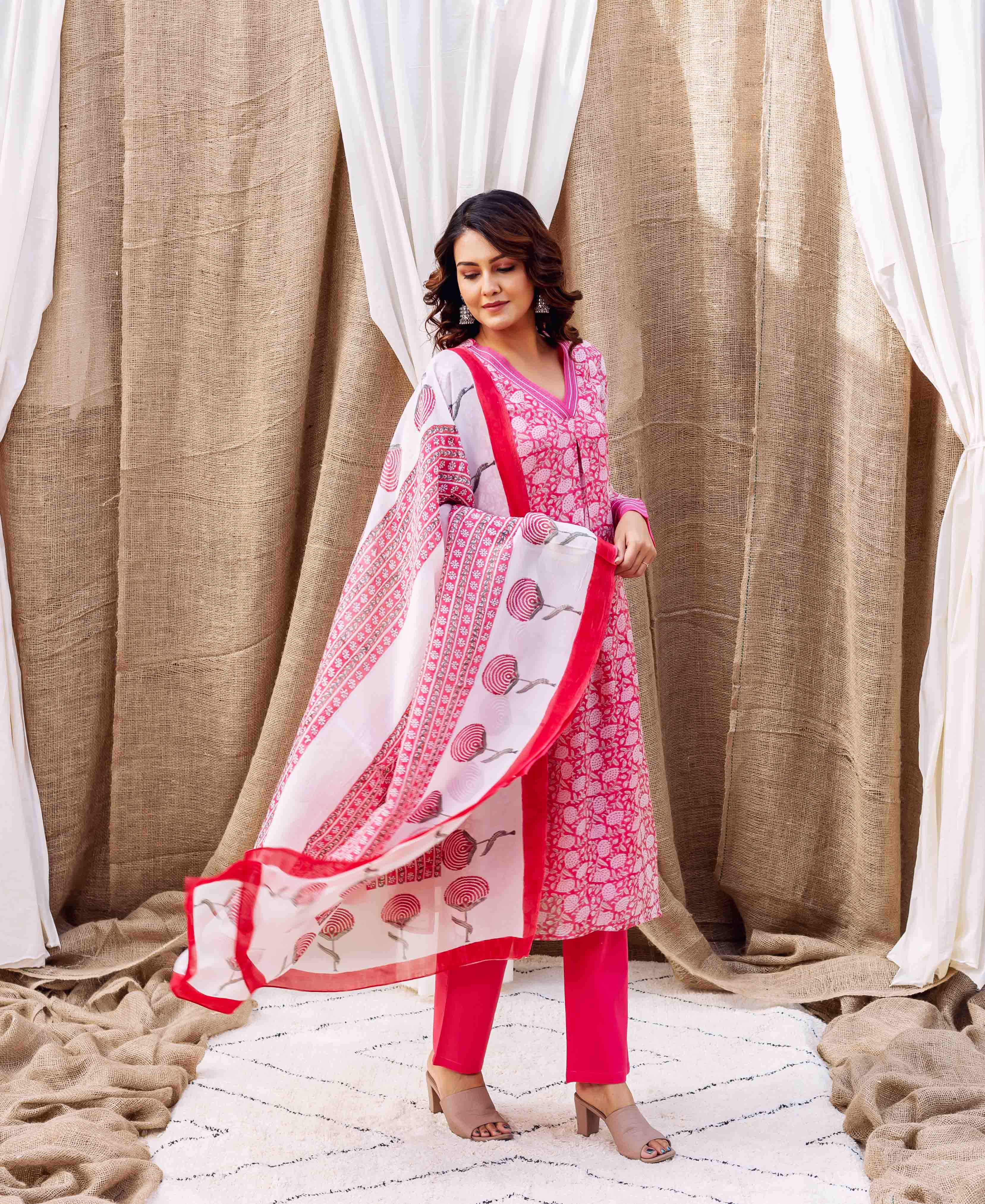 Model in pink ethnic suit, holding a white and pink hand-printed organza dupatta.