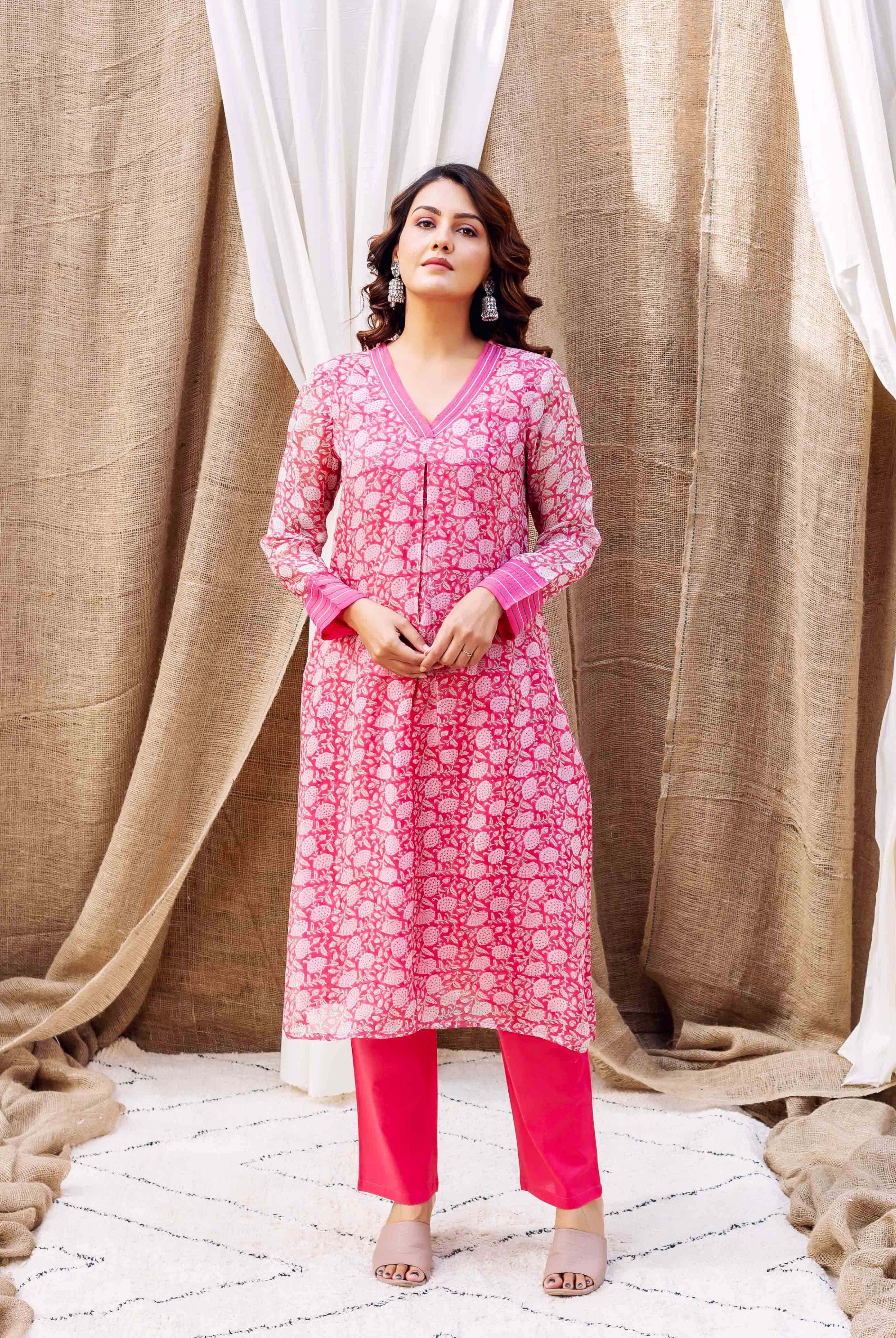 Model in a full shot, wearing a pink hand-block printed floral kurta and pants.
