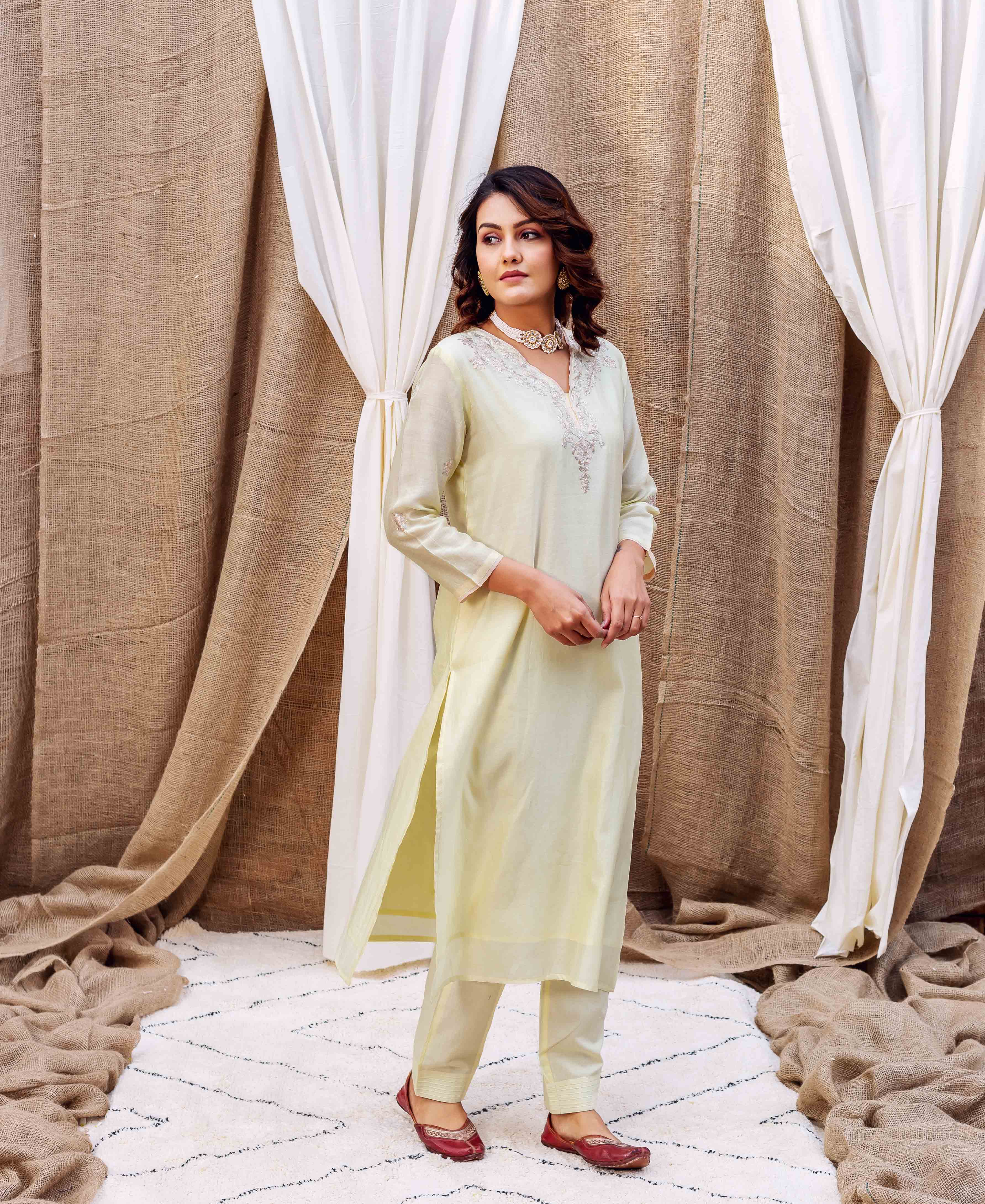 Model in a full-length pale yellow Pittan work kurta set with delicate embroidery.