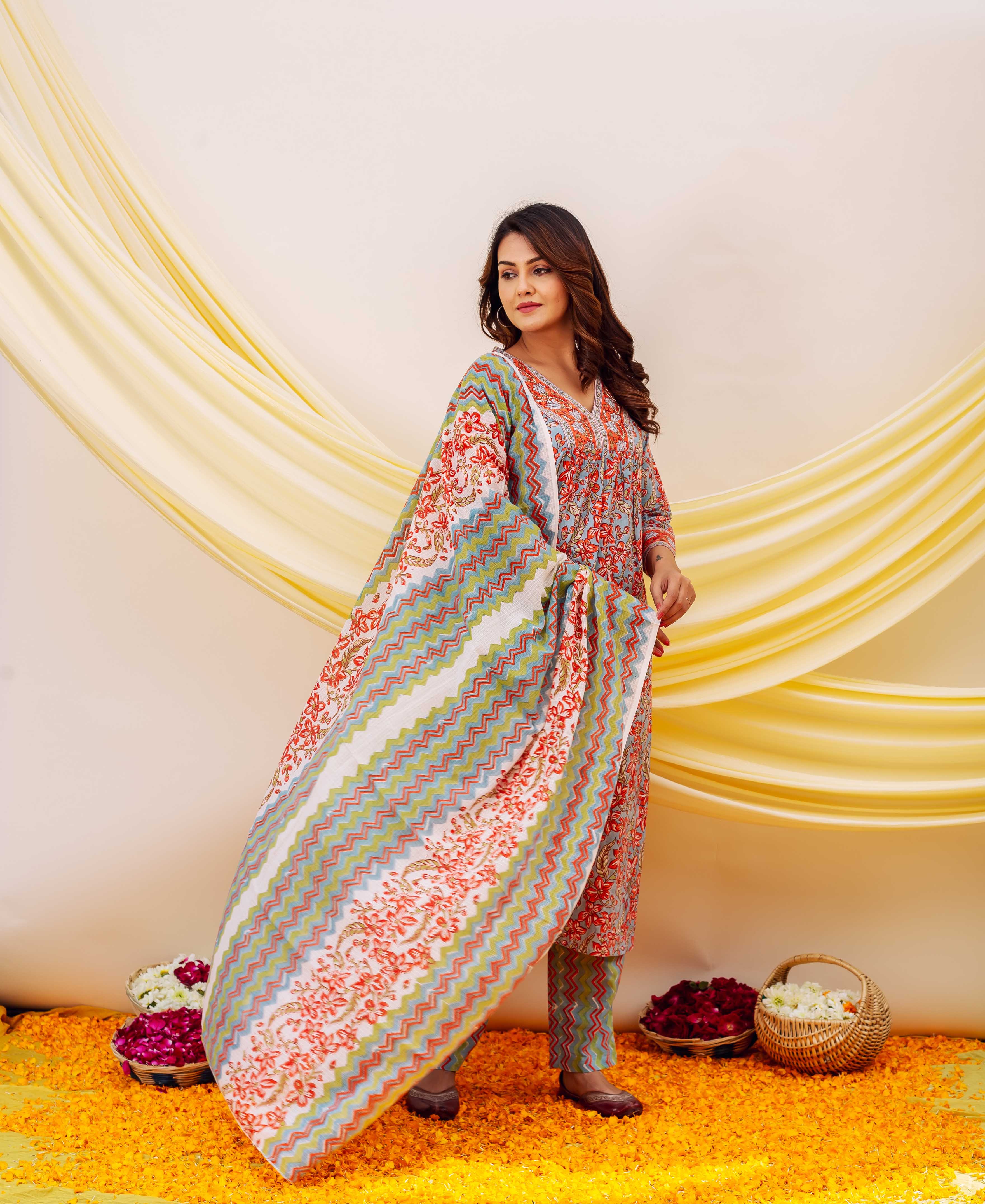 Model in a blue-grey and red floral print kurta set with a vibrant zigzag dupatta.