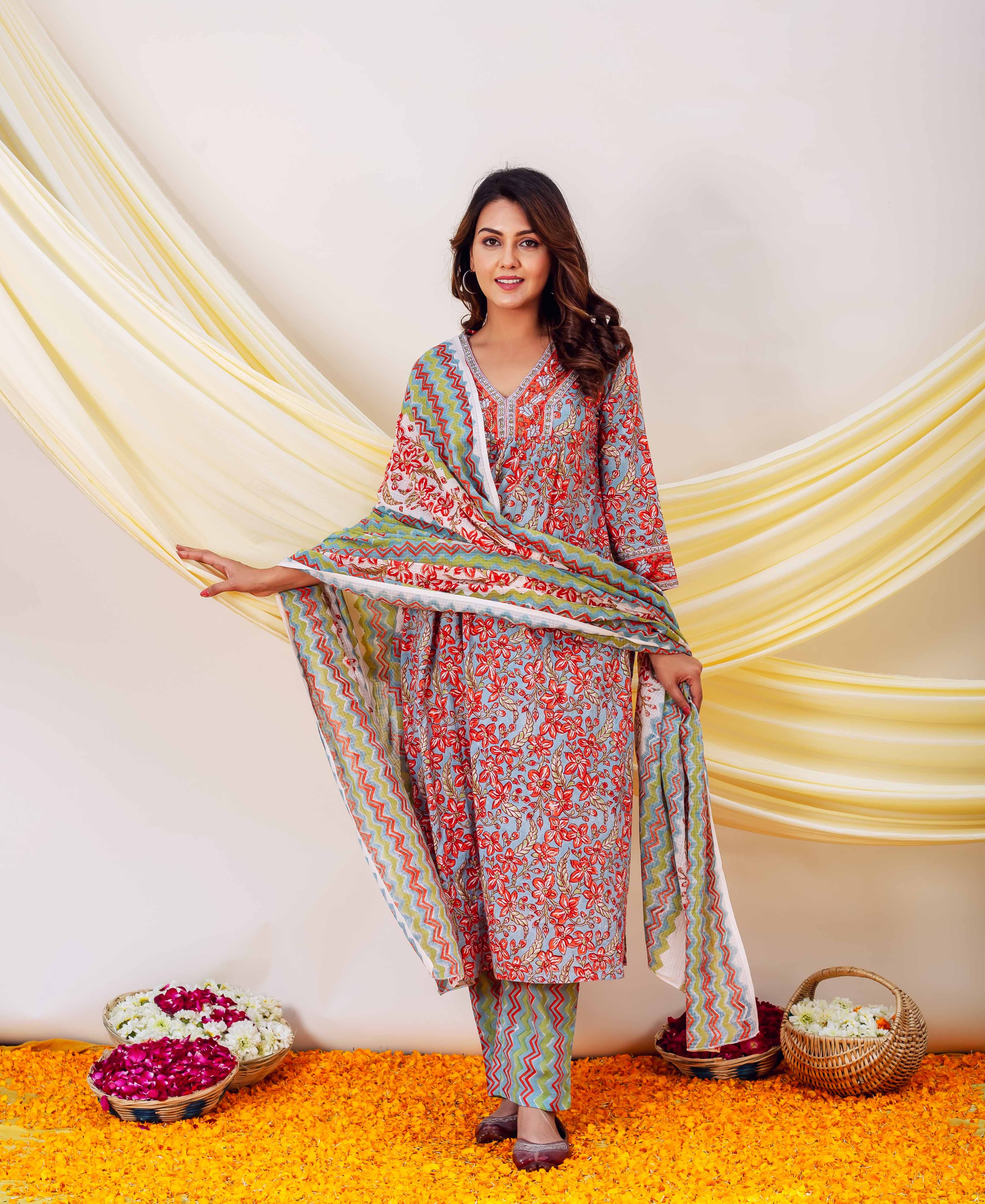 Woman wearing red, blue and yellow hand-block-printed kurta and pants with floral and zigzag pattern.