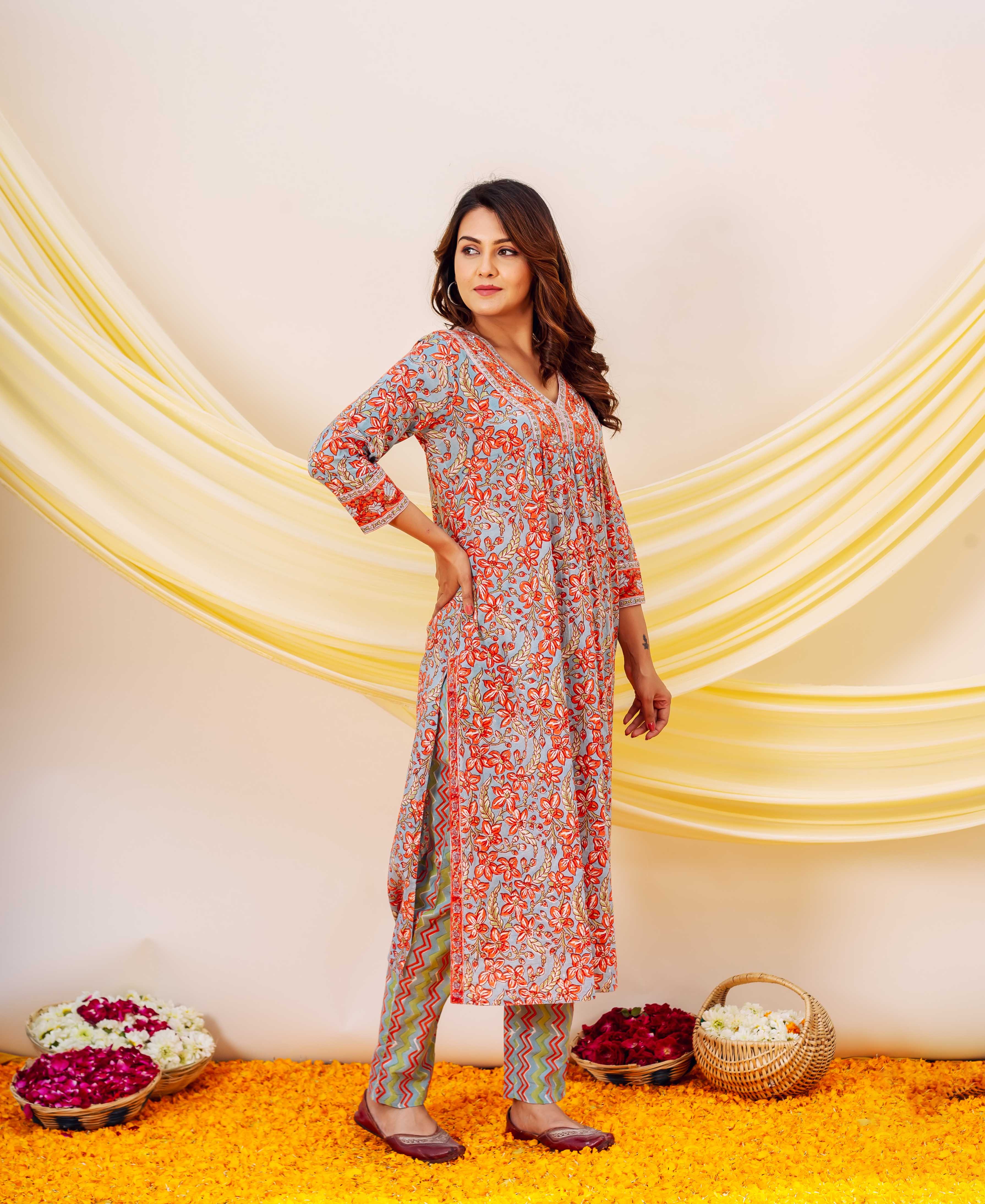 Side view of model in light blue and red floral block printed kurta with zigzag pattern bottoms.