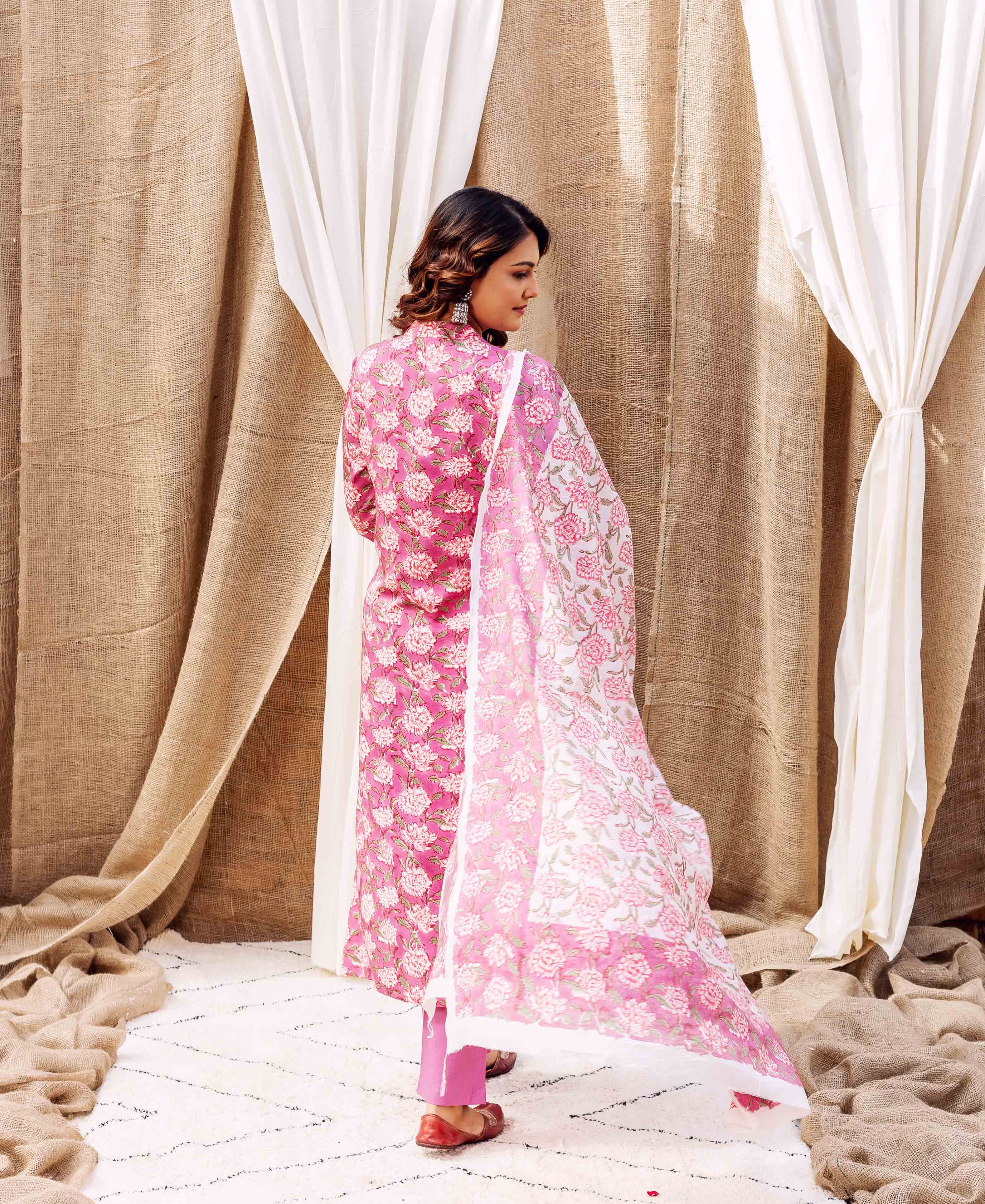 A woman in a pink floral kurta with a matching dupatta.