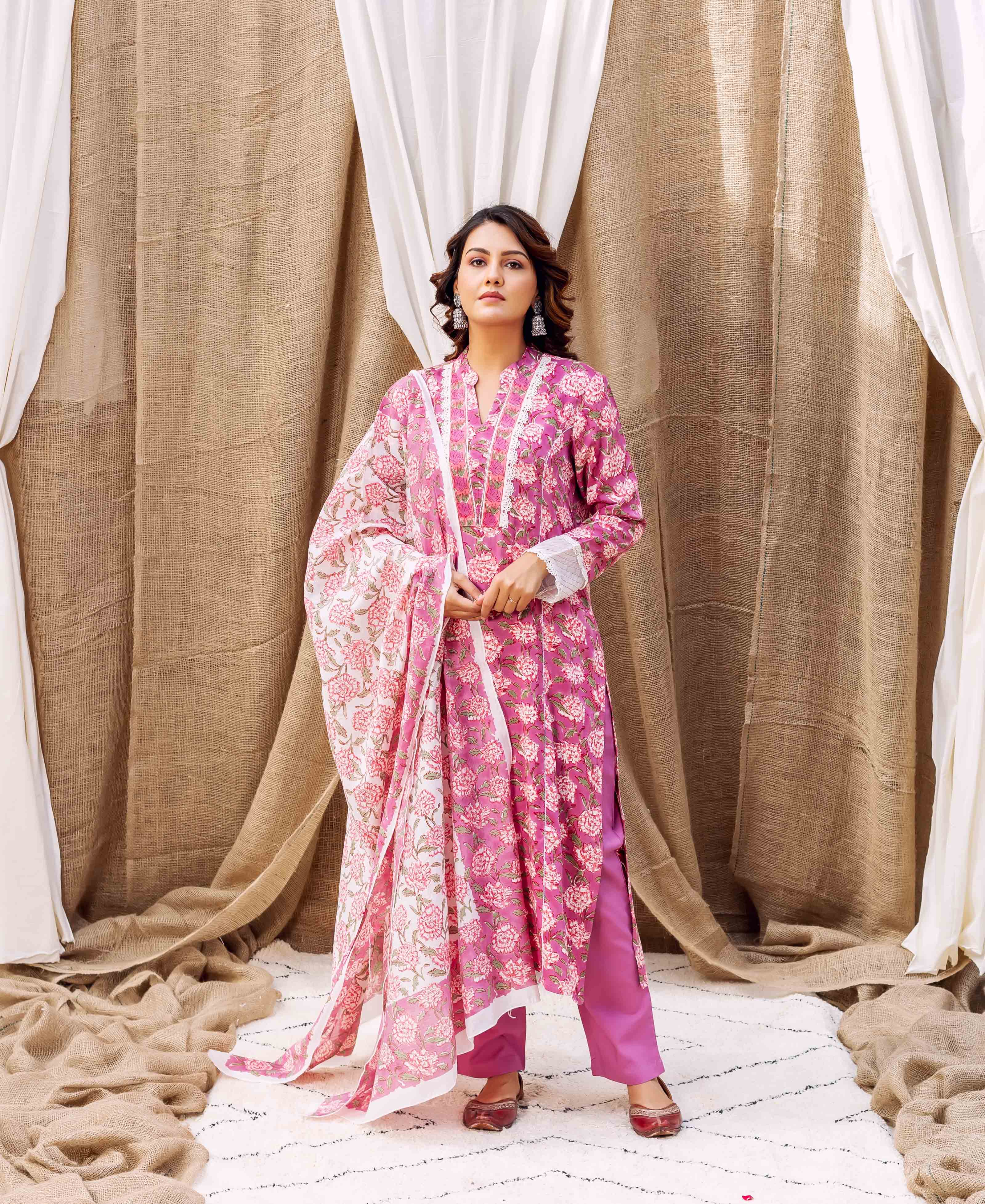 Model wearing a magenta floral hand-block-printed kurta set with matching dupatta.