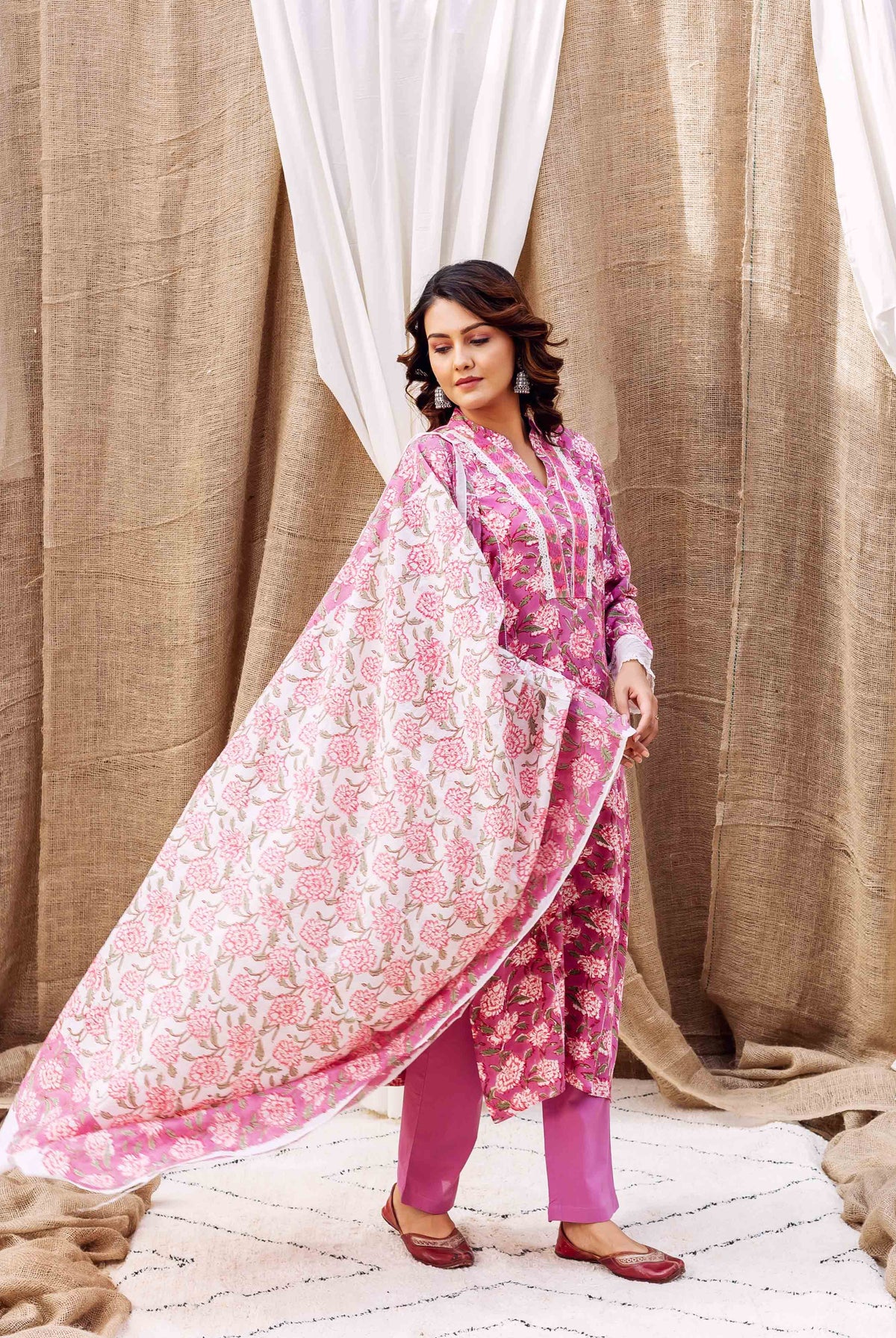 Model wearing a hand-block-printed lavender floral kurta set with a flowing pink and white dupatta.