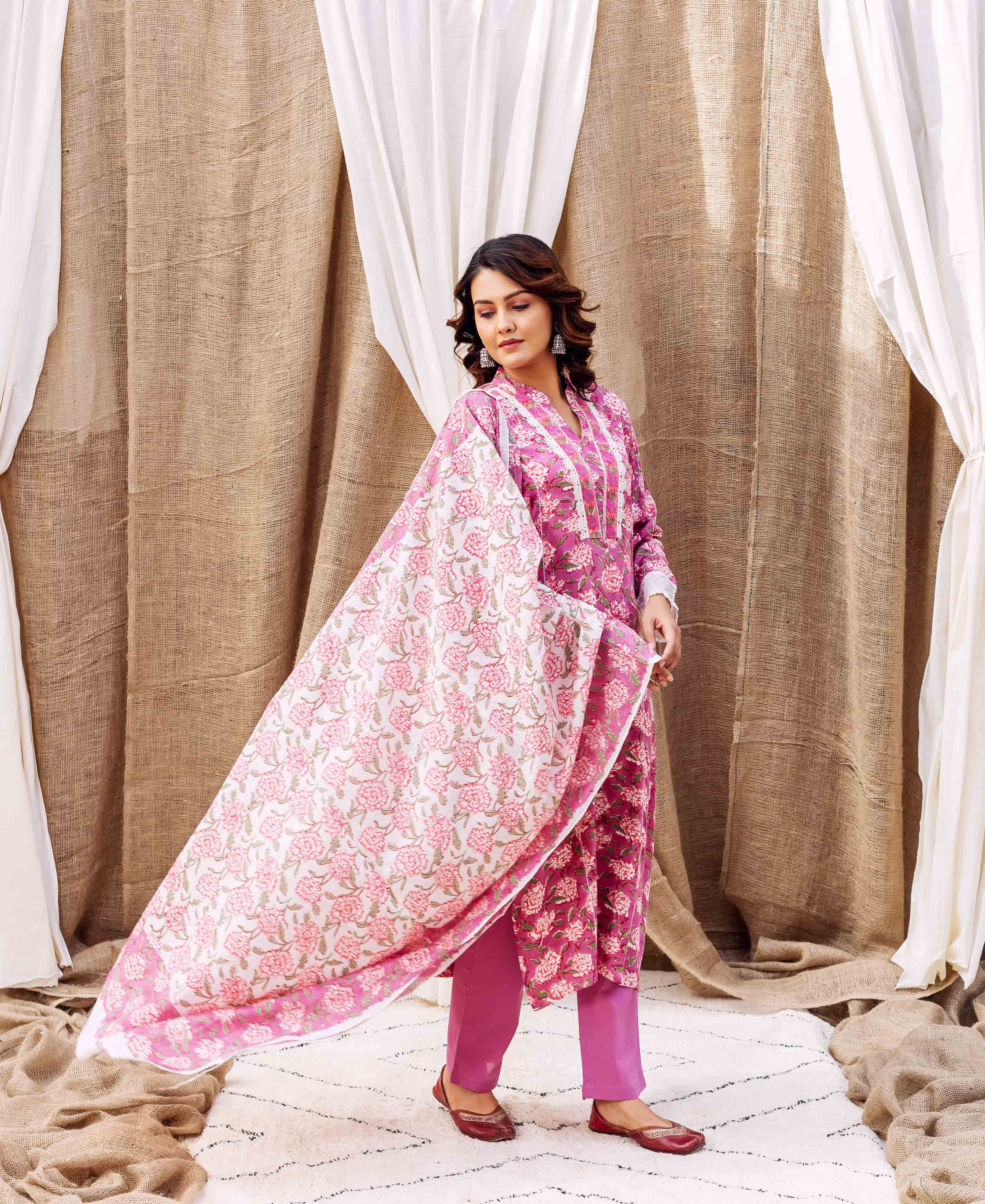 Model wearing a hand-block-printed lavender floral kurta set with a flowing pink and white dupatta.