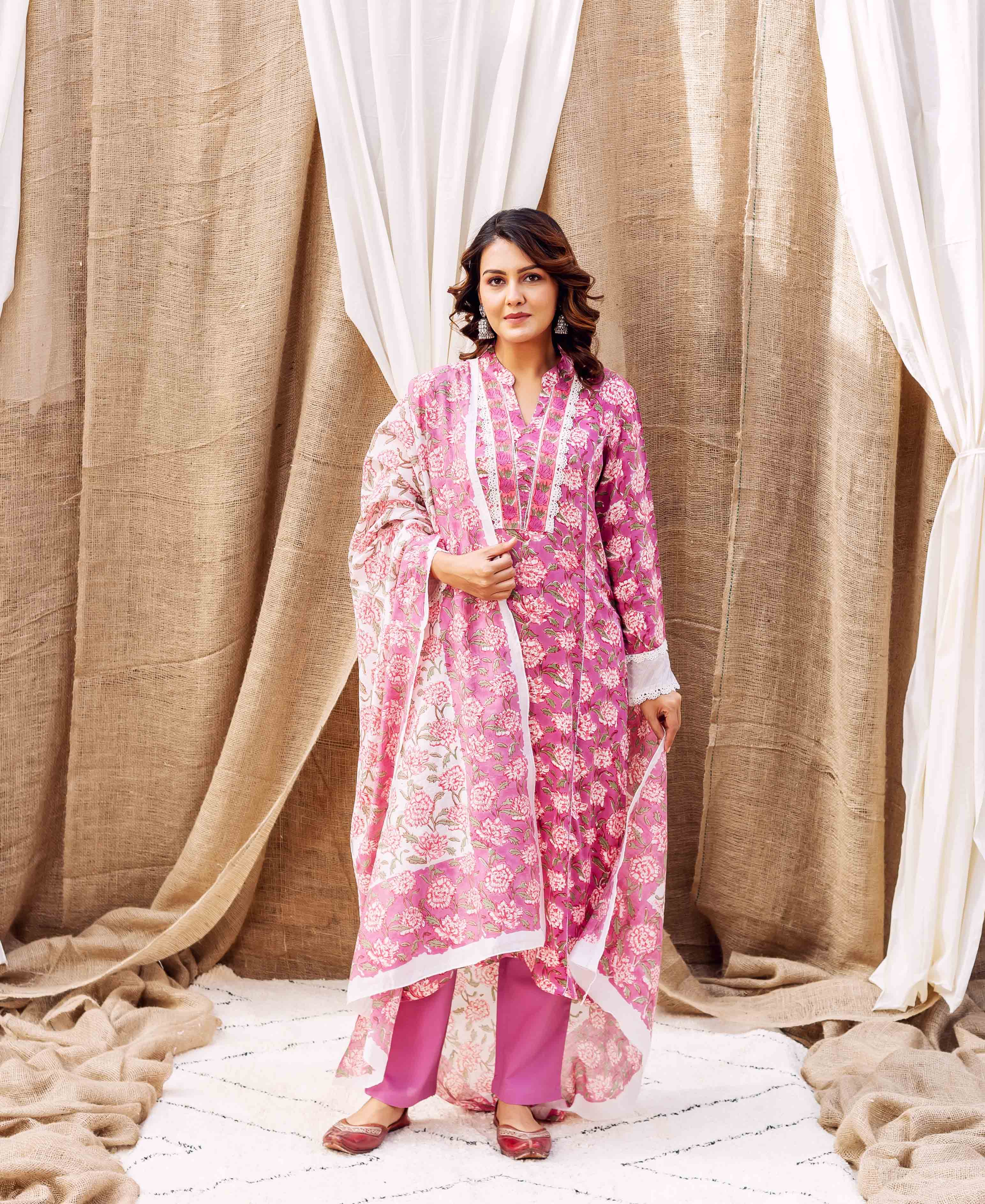 Vibrant pink floral hand-block-printed ethnic kurta set on a standing woman.