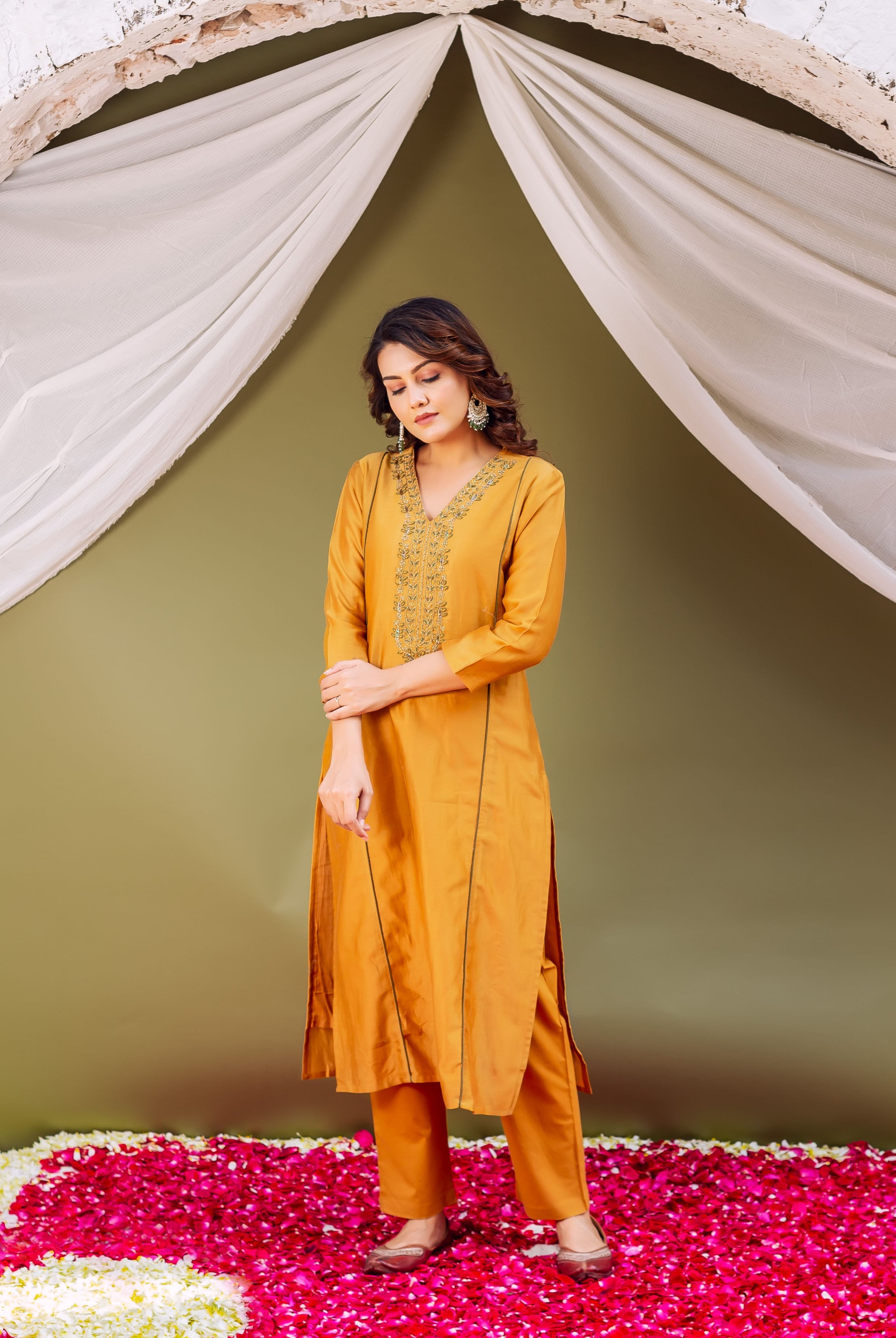 Model wearing a mustard silk chanderi kurta set with intricate hand-block printed neckline.