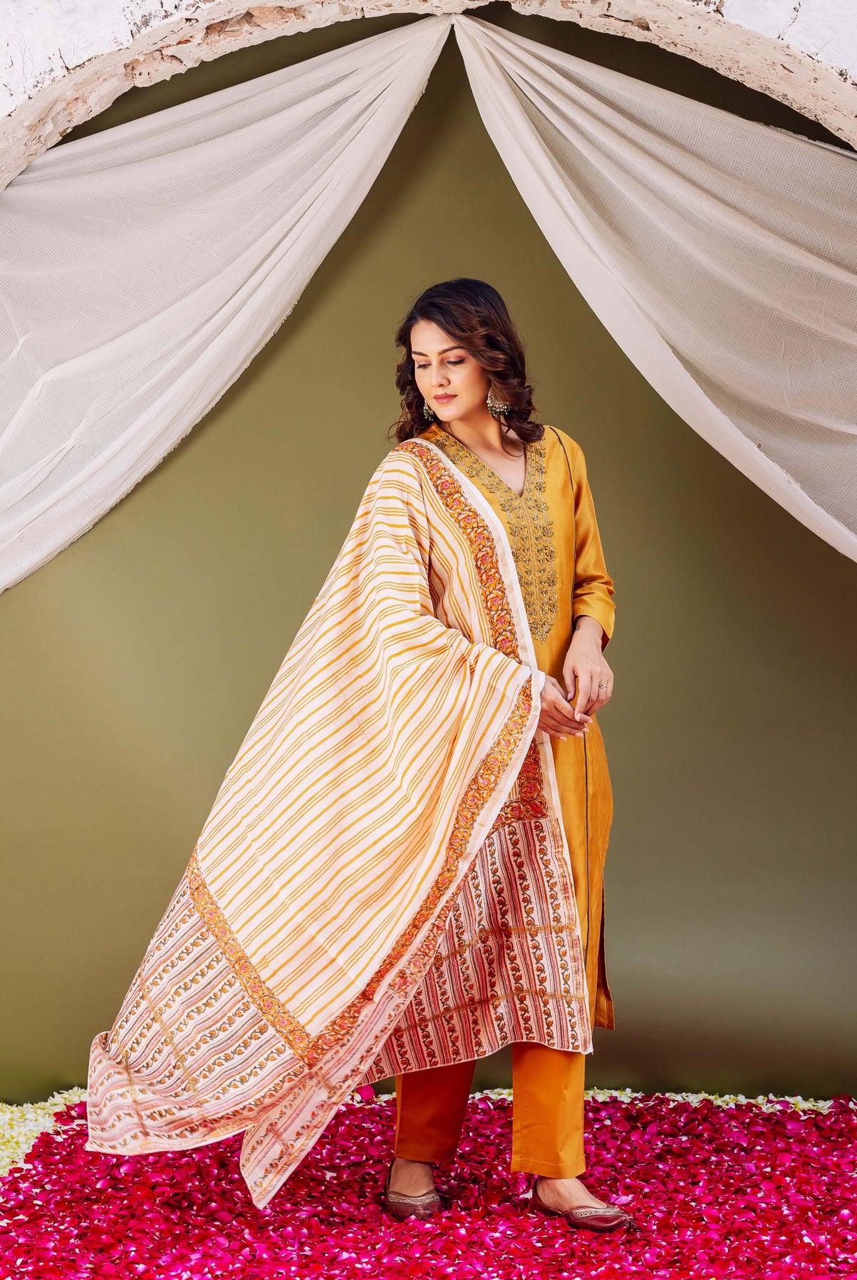 Model in mustard Chanderi kurta set with embroidered neck and block-printed striped dupatta.