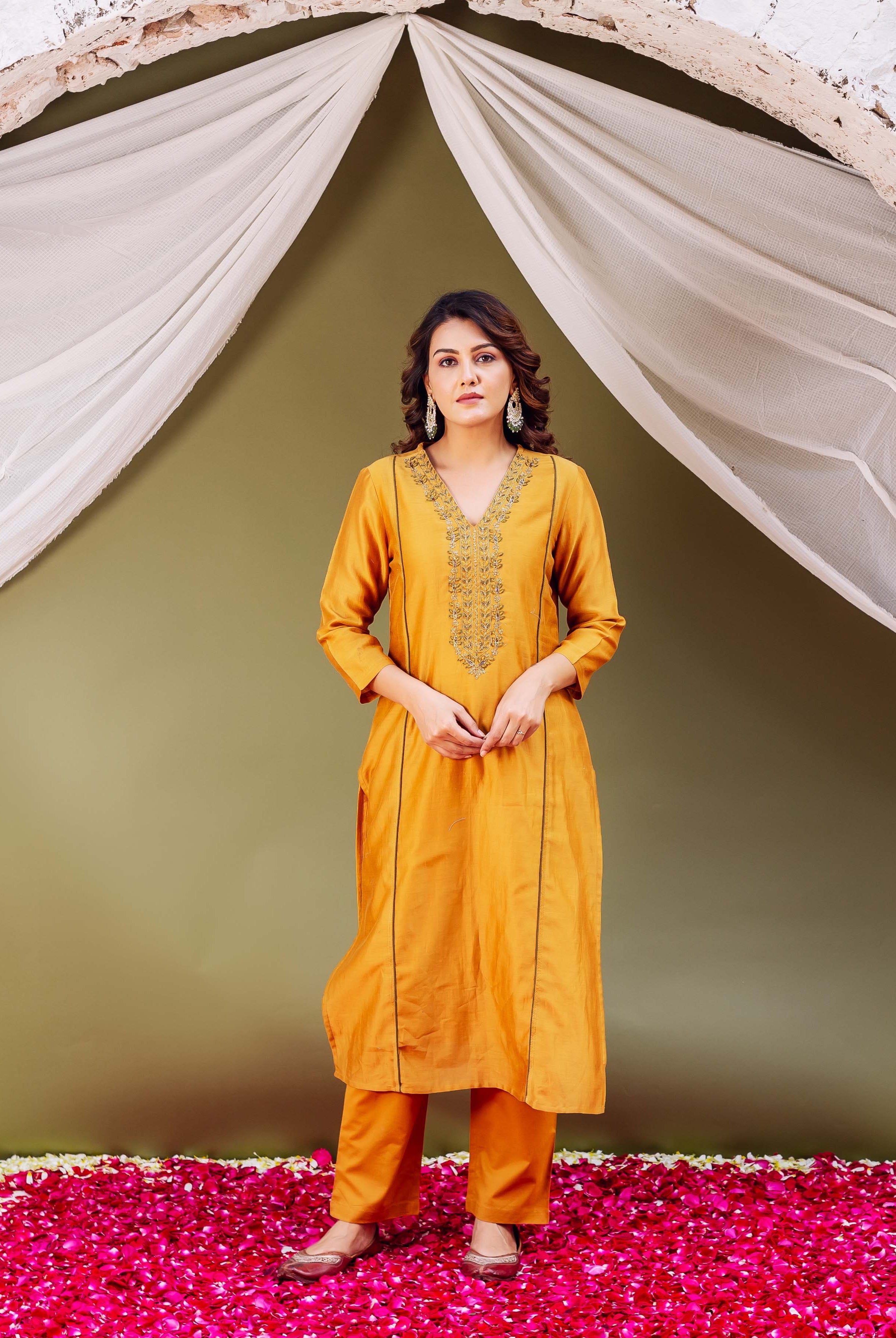 Mustard silk Chanderi kurta with gold embroidered V-neck and matching pants worn by model.