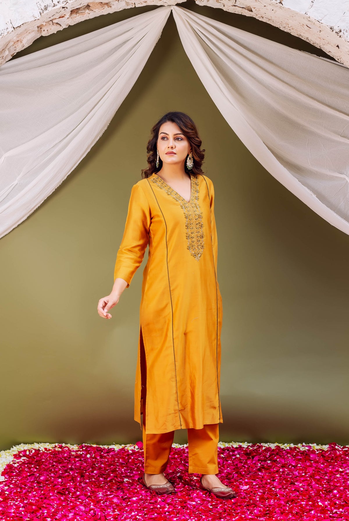 Full-body model wears mustard silk chanderi kurta set with intricate gold embroidered V-neck.