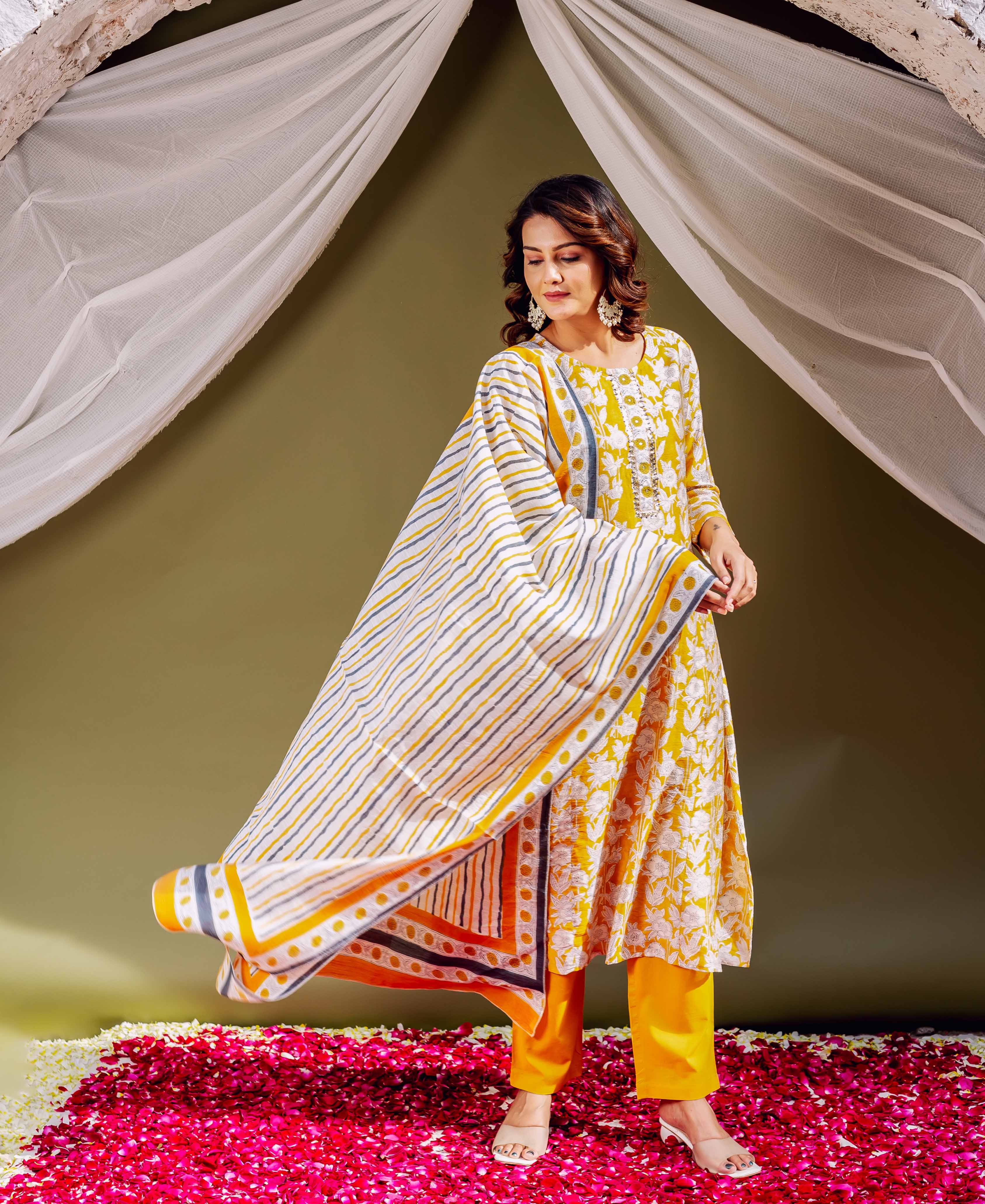 Model in sunflower yellow hand block printed kurta set with fanned striped dupatta.