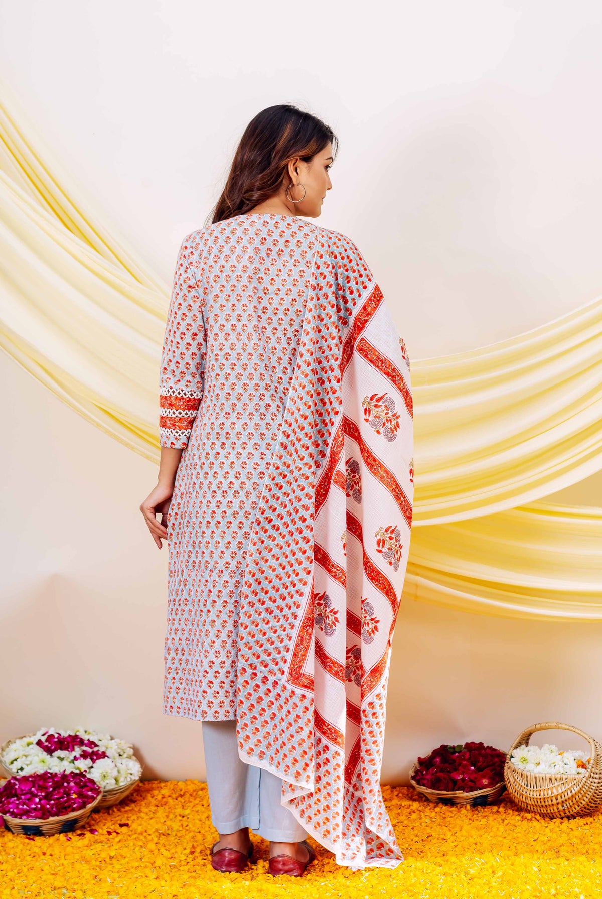 Light blue cotton hand-block printed kurta set with orange floral patterns, back view.