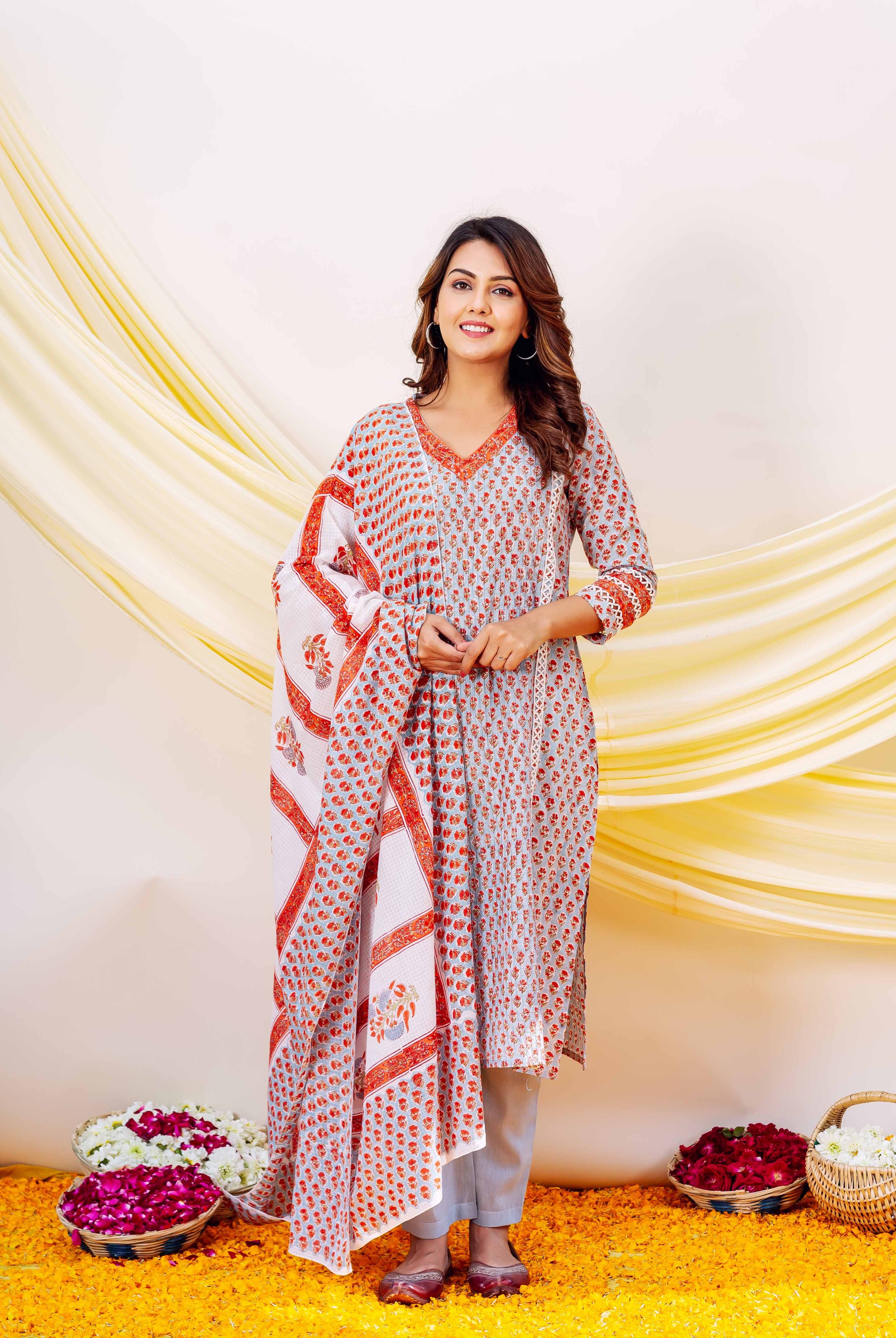 Smiling woman wearing a full-length, light blue and red floral hand block printed cotton kurta set.