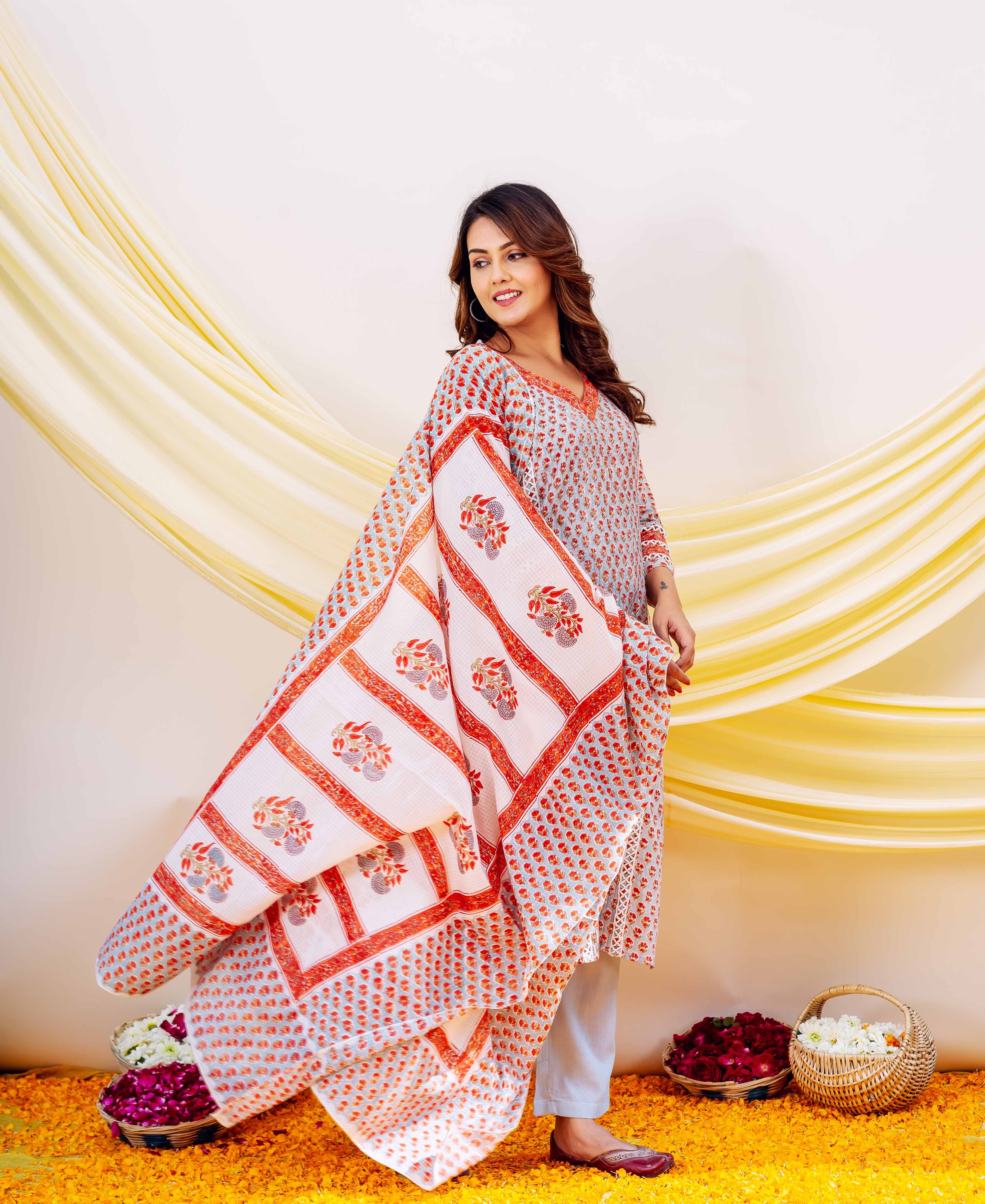 Model wearing a flowing white Kota Doriya dupatta with prominent orange and red hand block prints.