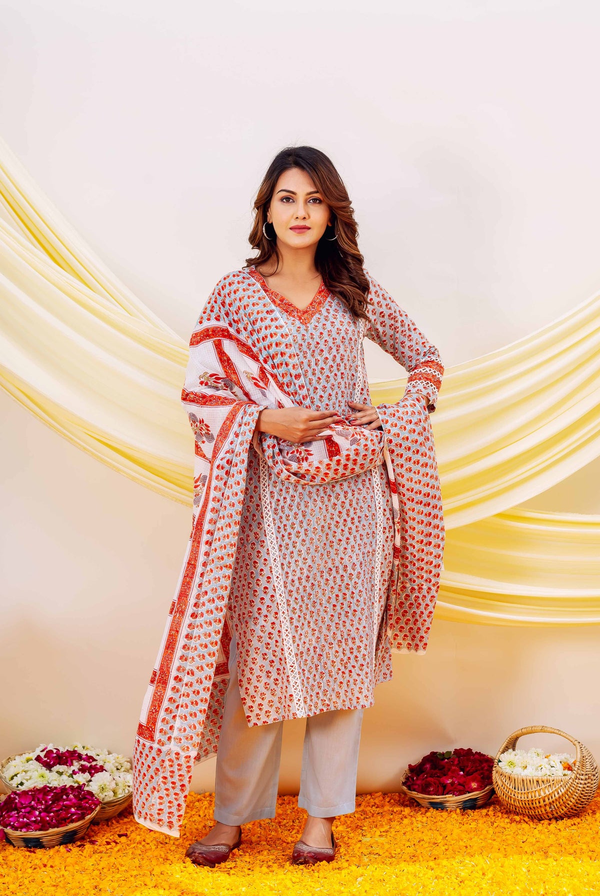 Front view model wearing light blue hand-block printed kurta set with red-orange floral print.