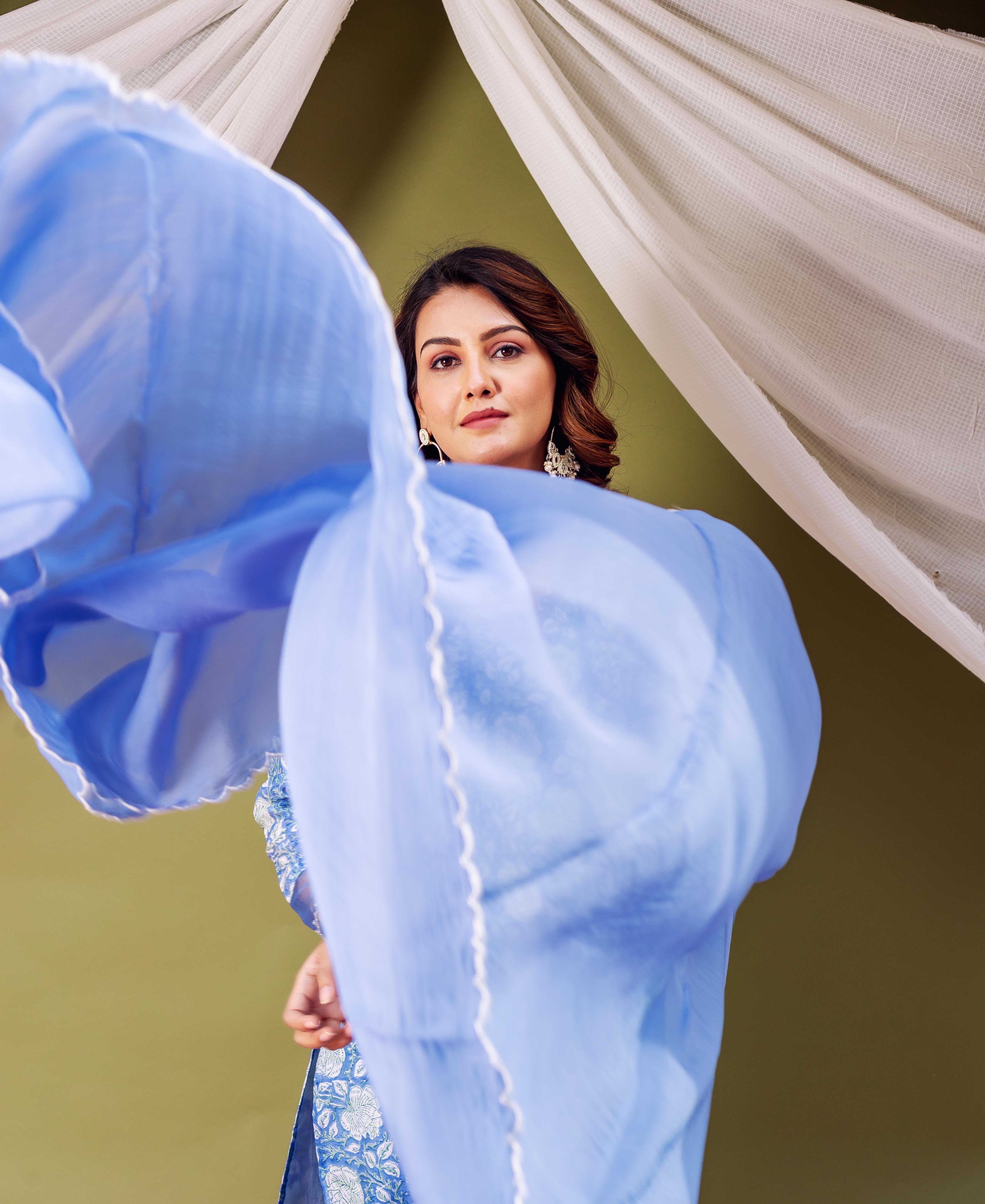 Light blue organza dupatta with white stitching and floral print trim on woman.