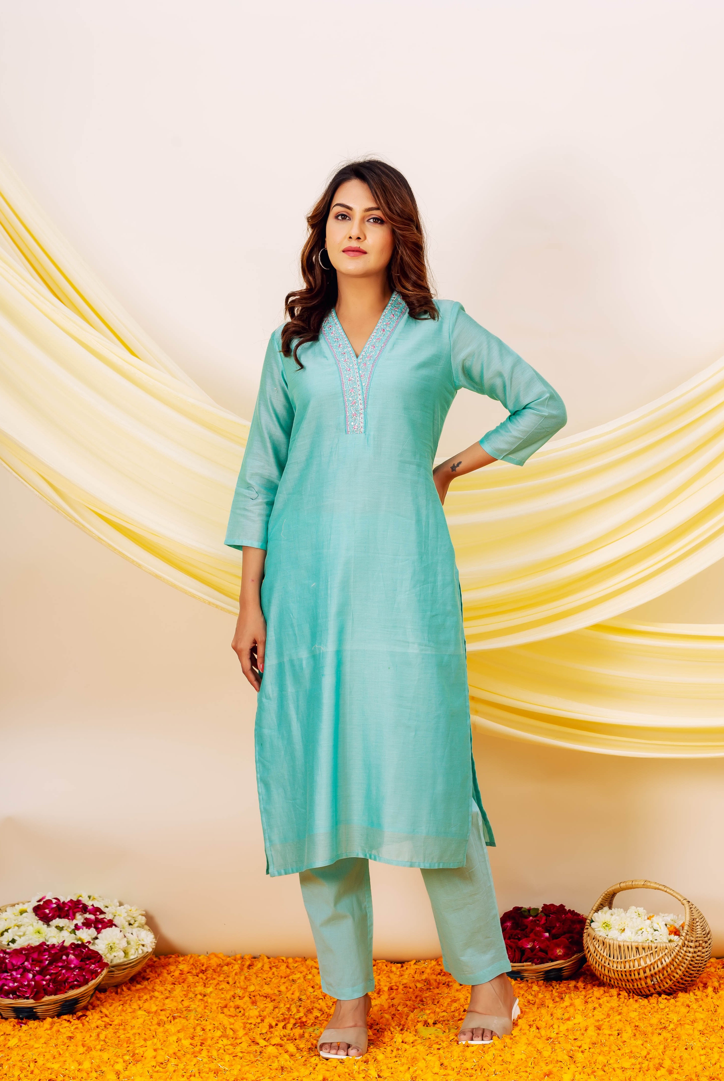 Front view of a model wearing an aqua Chanderi silk kurta set with embroidered V-neck.