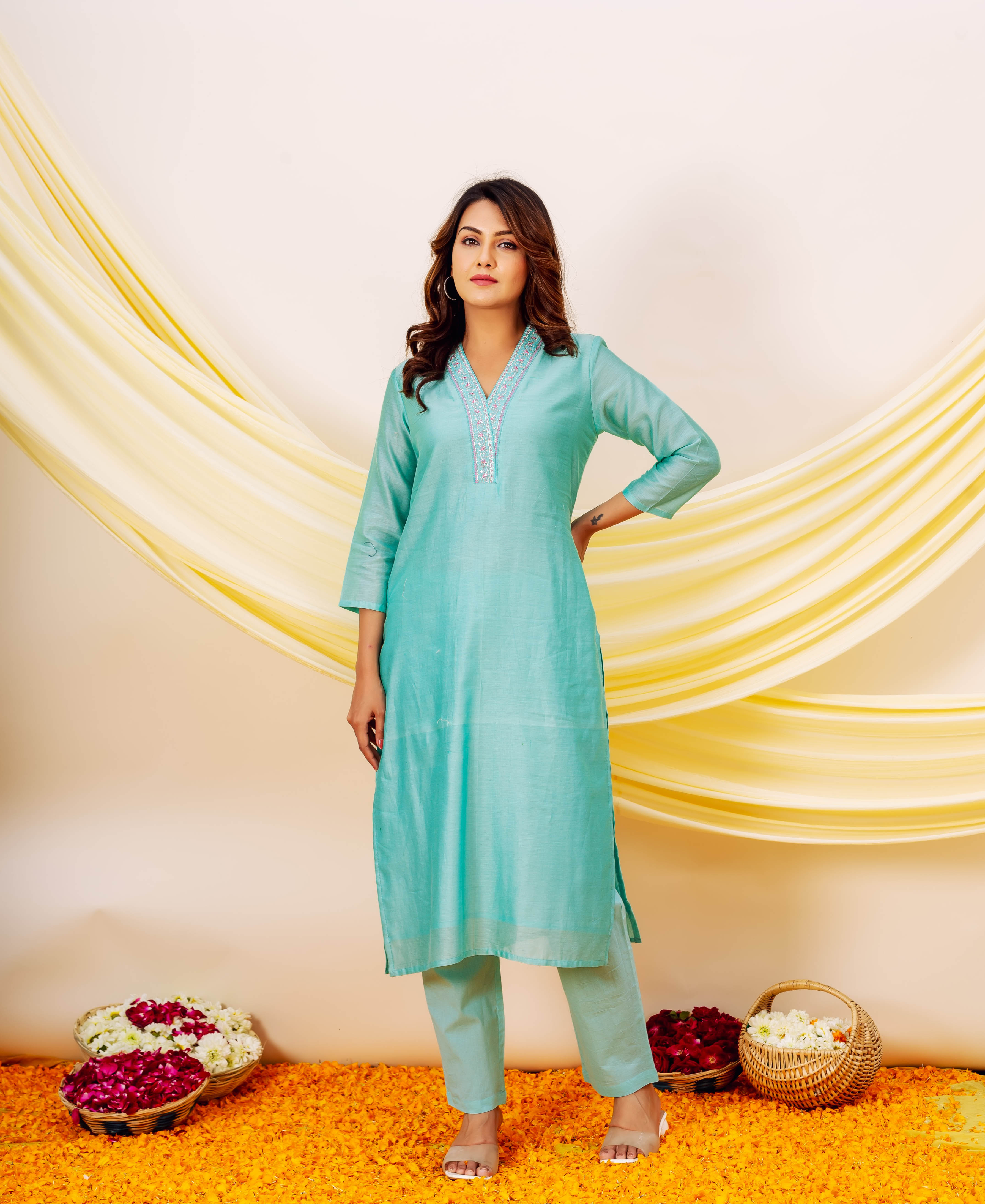 Front view of a model wearing an aqua Chanderi silk kurta set with embroidered V-neck.