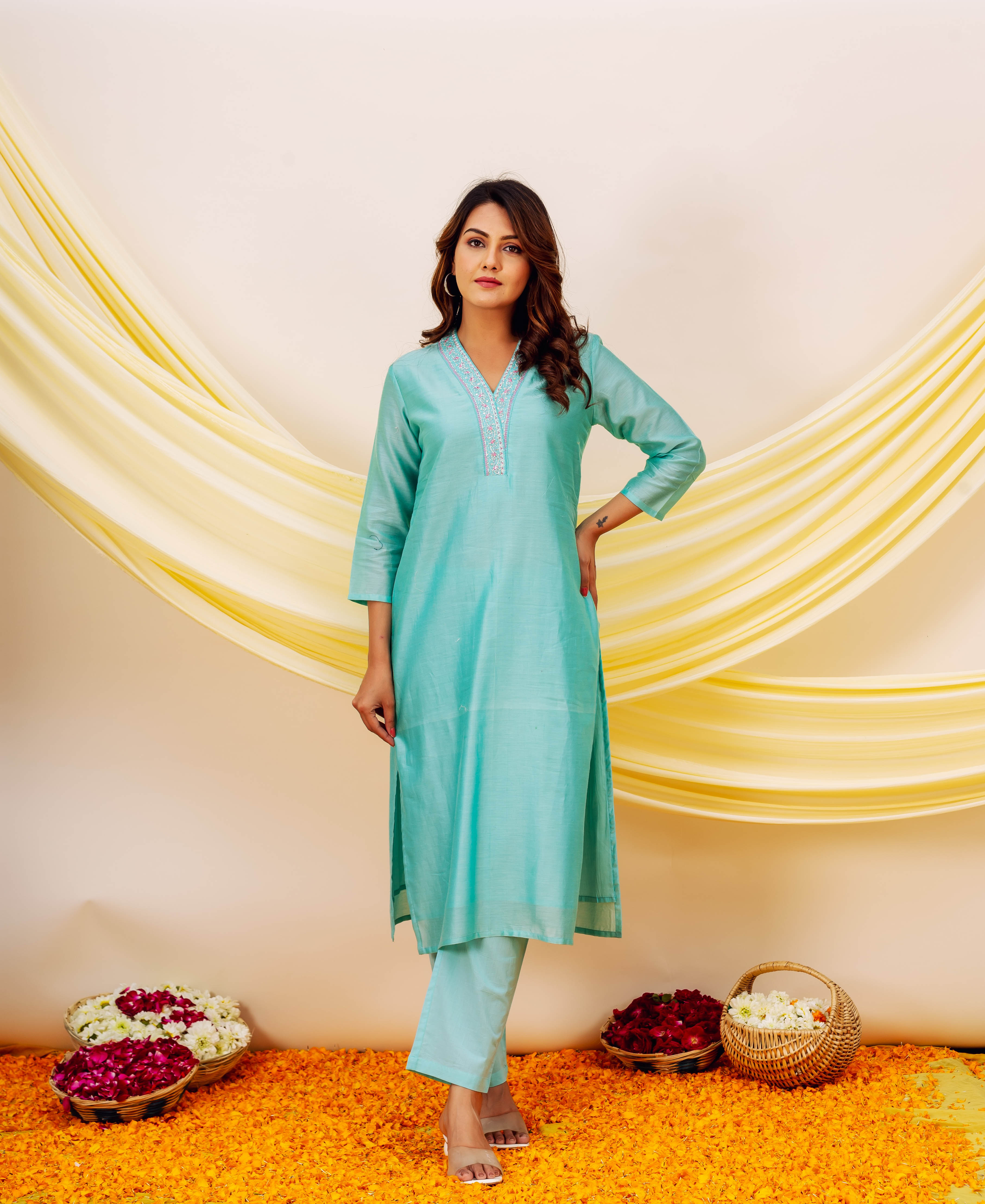 Model wears full aqua kurta set with delicate embroidered V-neckline.