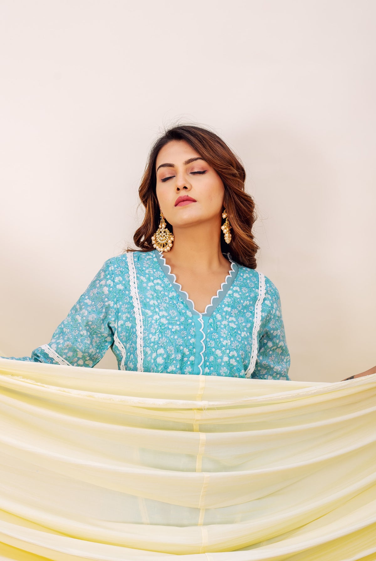 Model wears blue hand-block printed chanderi kurta featuring white floral design and V-neck.