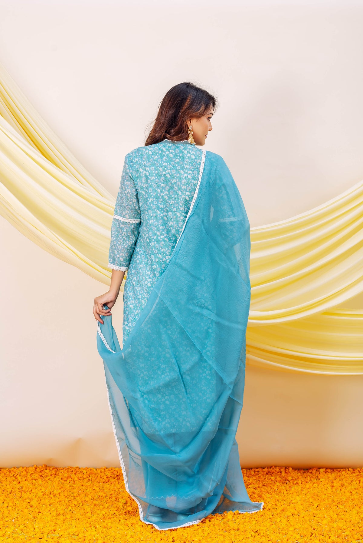 Back view of model in blue hand-block printed chanderi kurta, white floral design, and matching dupatta.