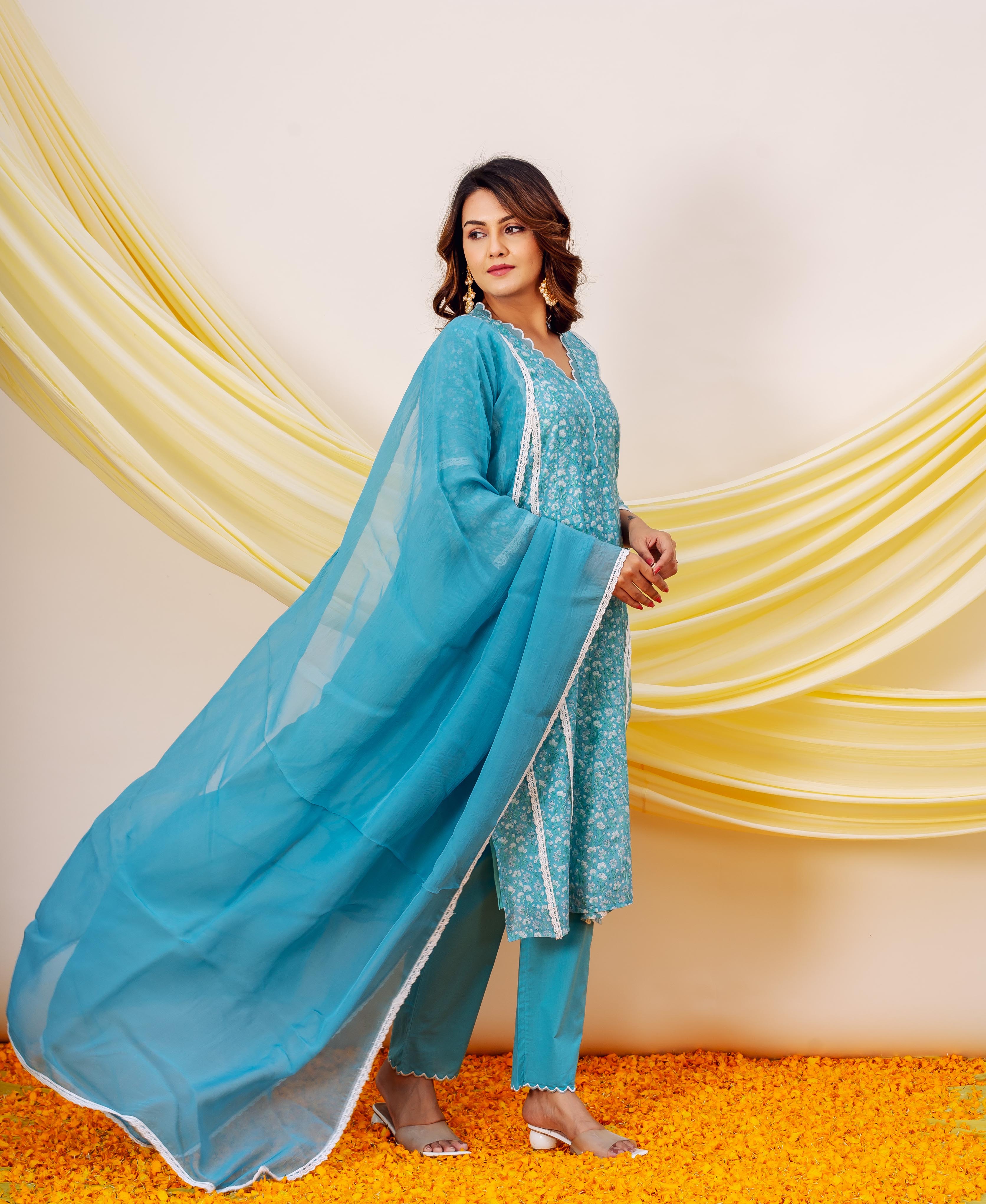 Side view of model in blue floral hand-block-printed kurta set with organza dupatta.