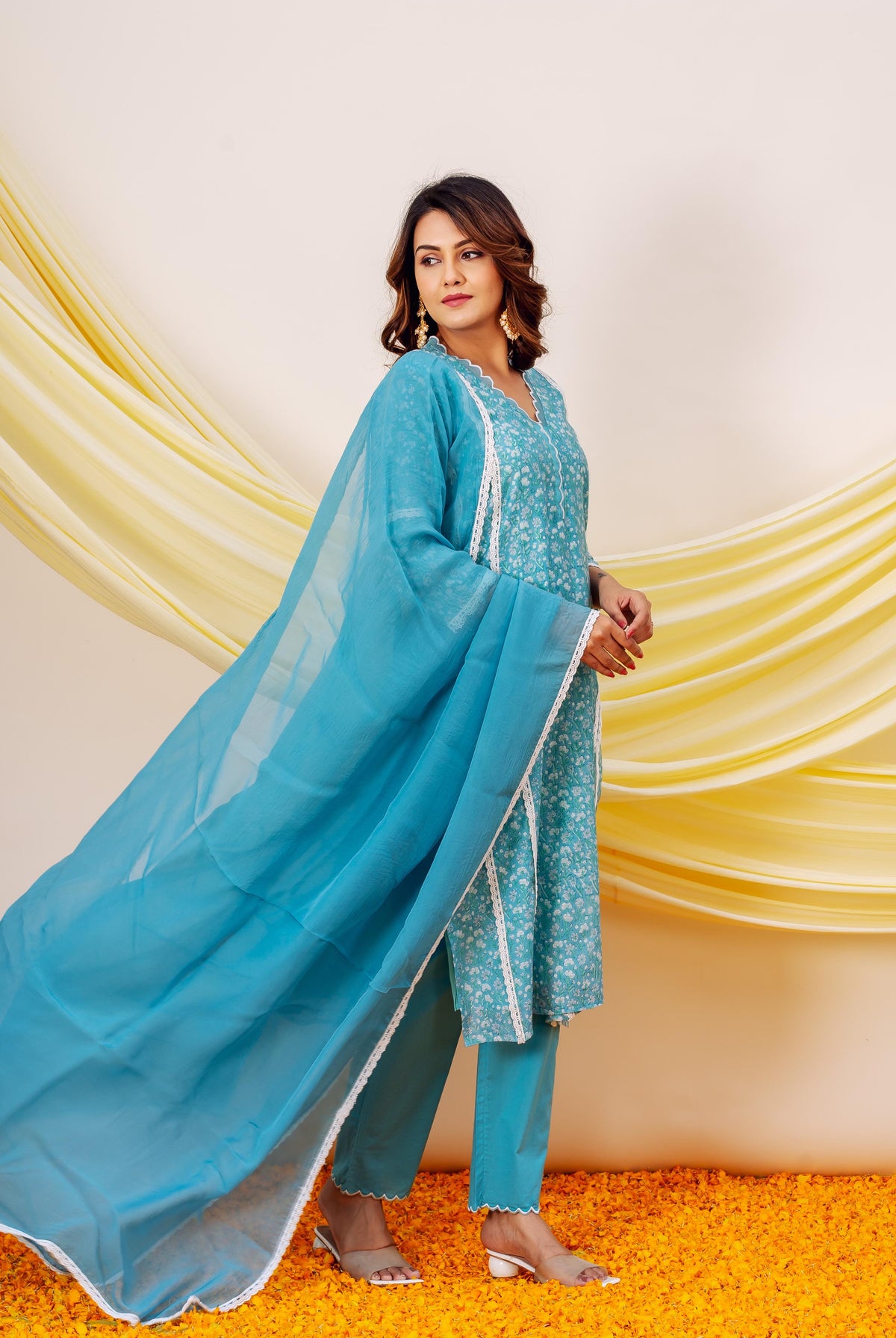 Side view: model in blue hand block printed kurta set with white trim and flowing dupatta.