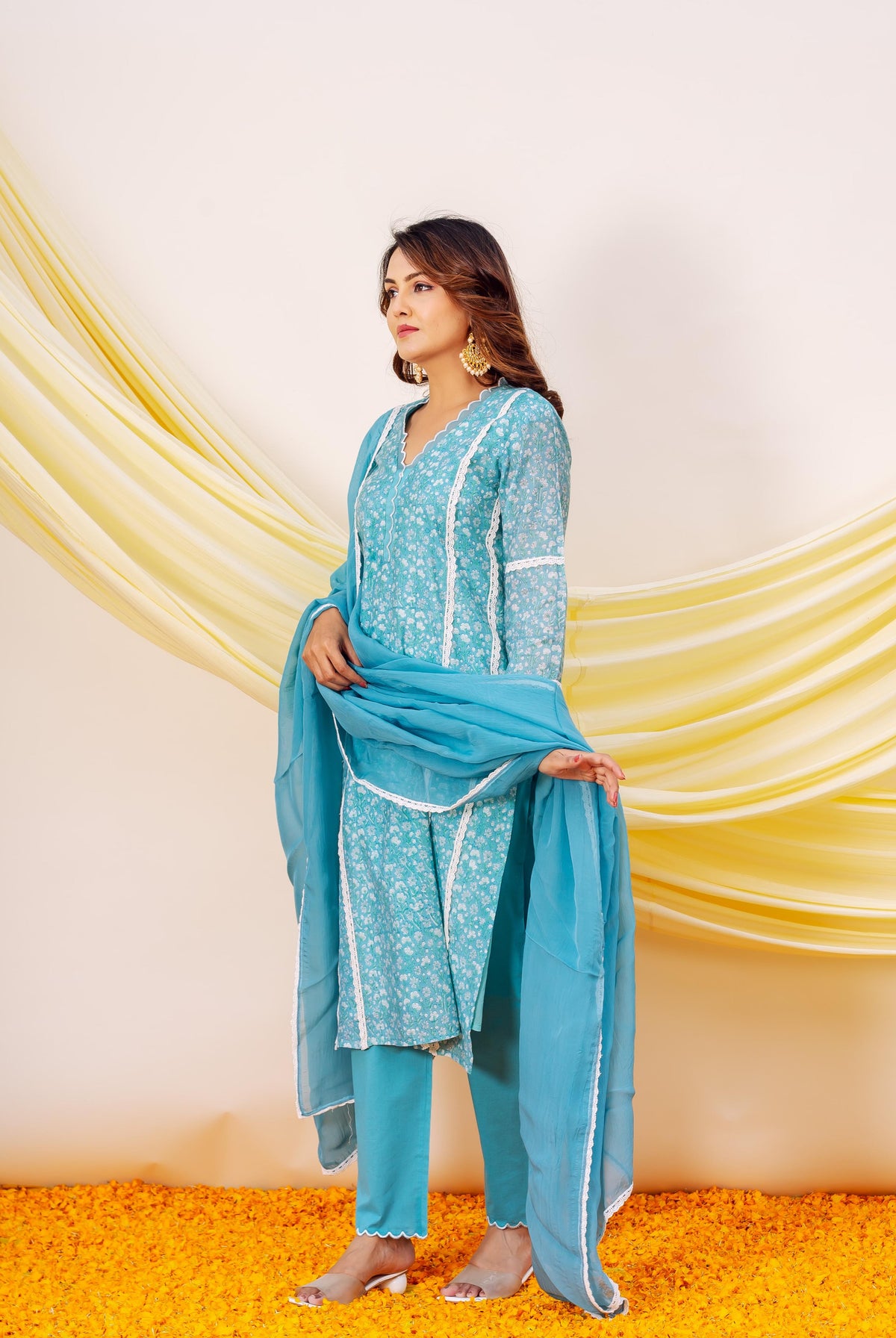 Model in blue hand block printed kurta set with delicate white floral design and lace trim.
