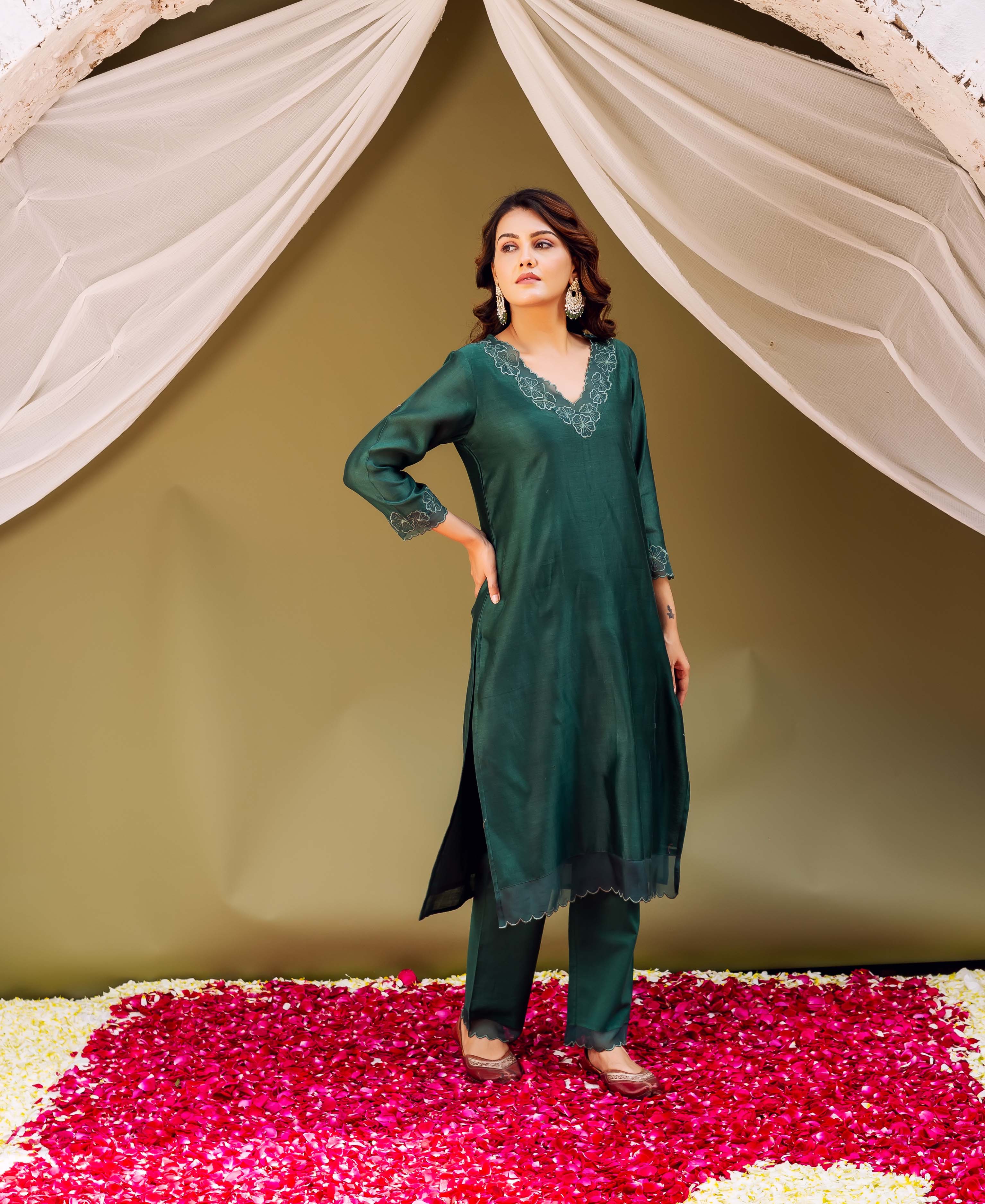 Regal forest green silk kurta set on model with intricate white embroidered neckline and cuffs.