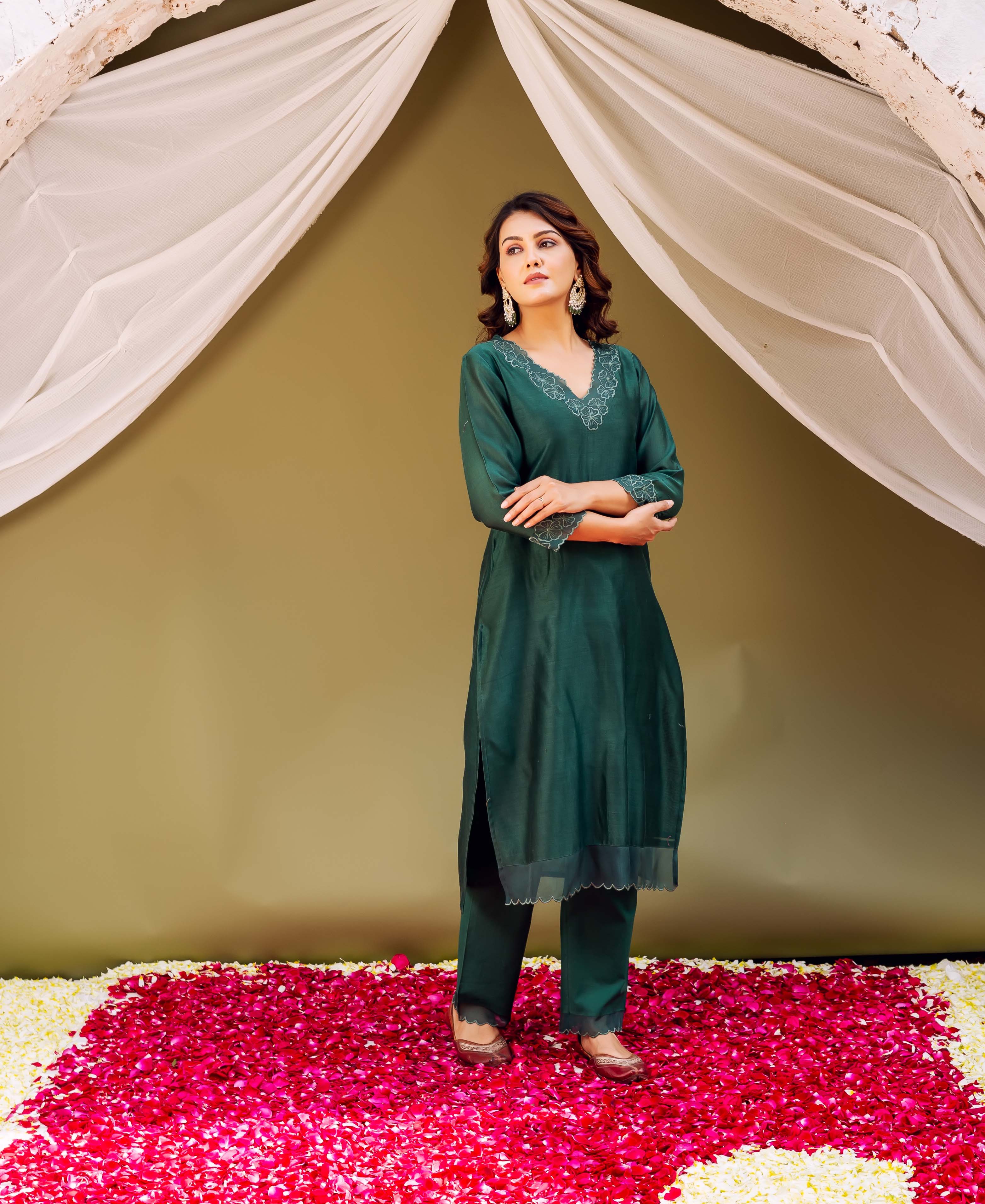 Woman modeling a forest green silk chanderi kurta set with intricate white embroidery.