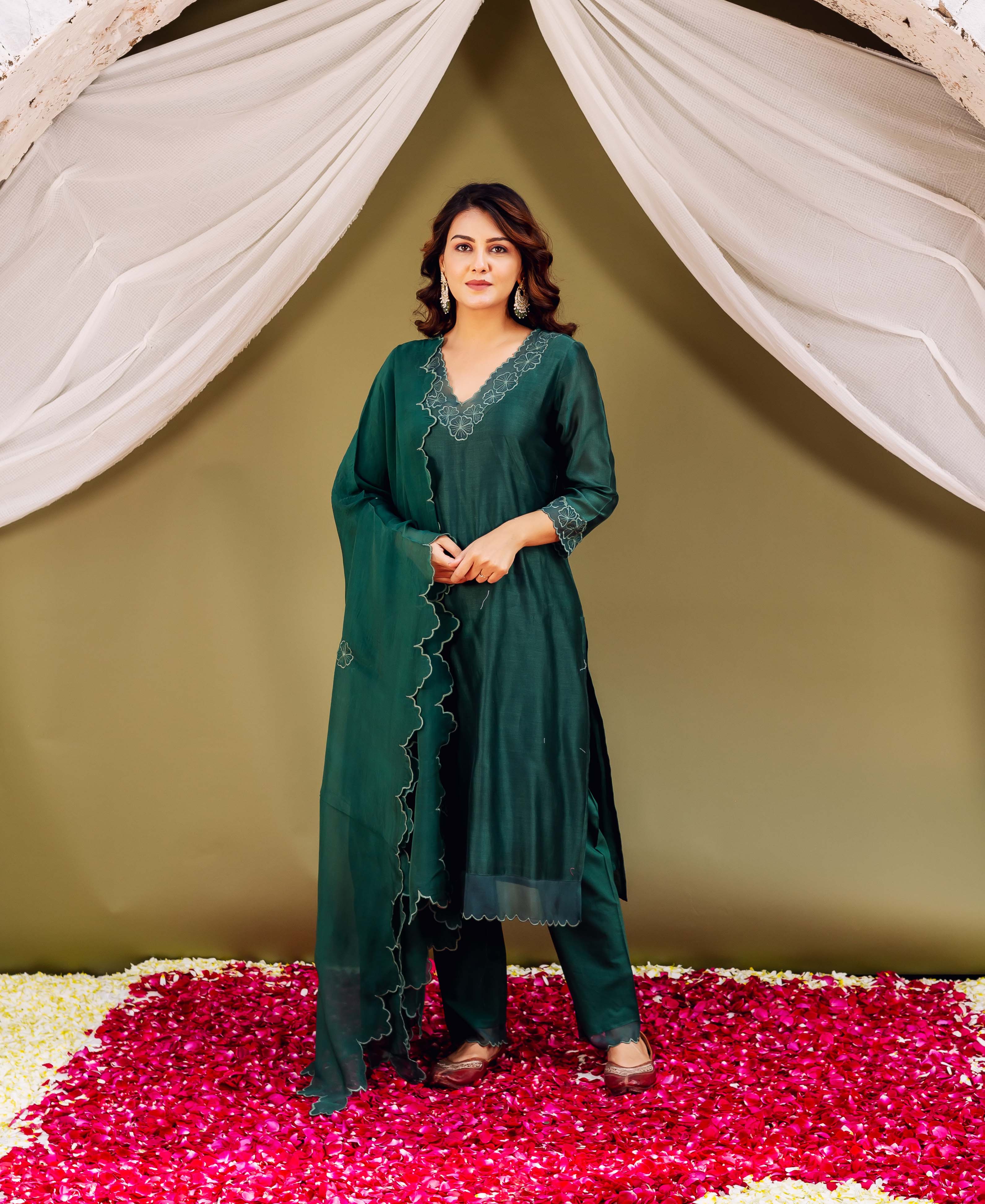 Woman in regal forest green silk Chanderi ensemble featuring delicate white embroidery details.