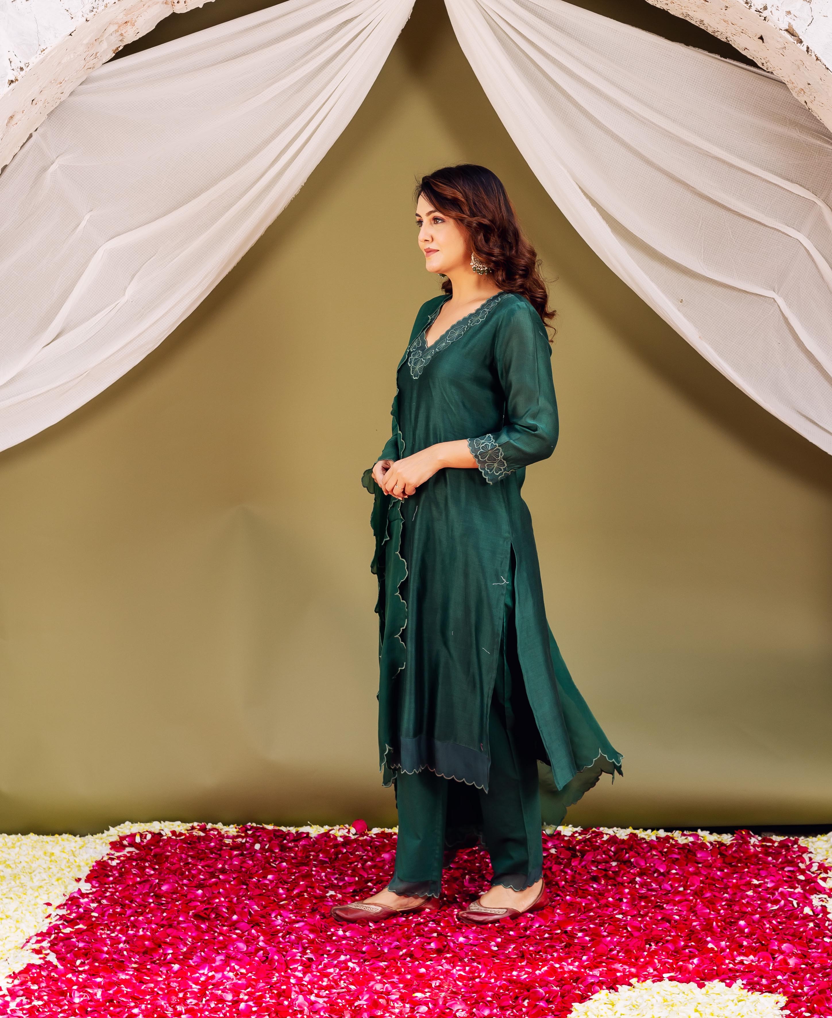 Model in full-body side view wearing deep forest green silk chanderi with white scalloped print.