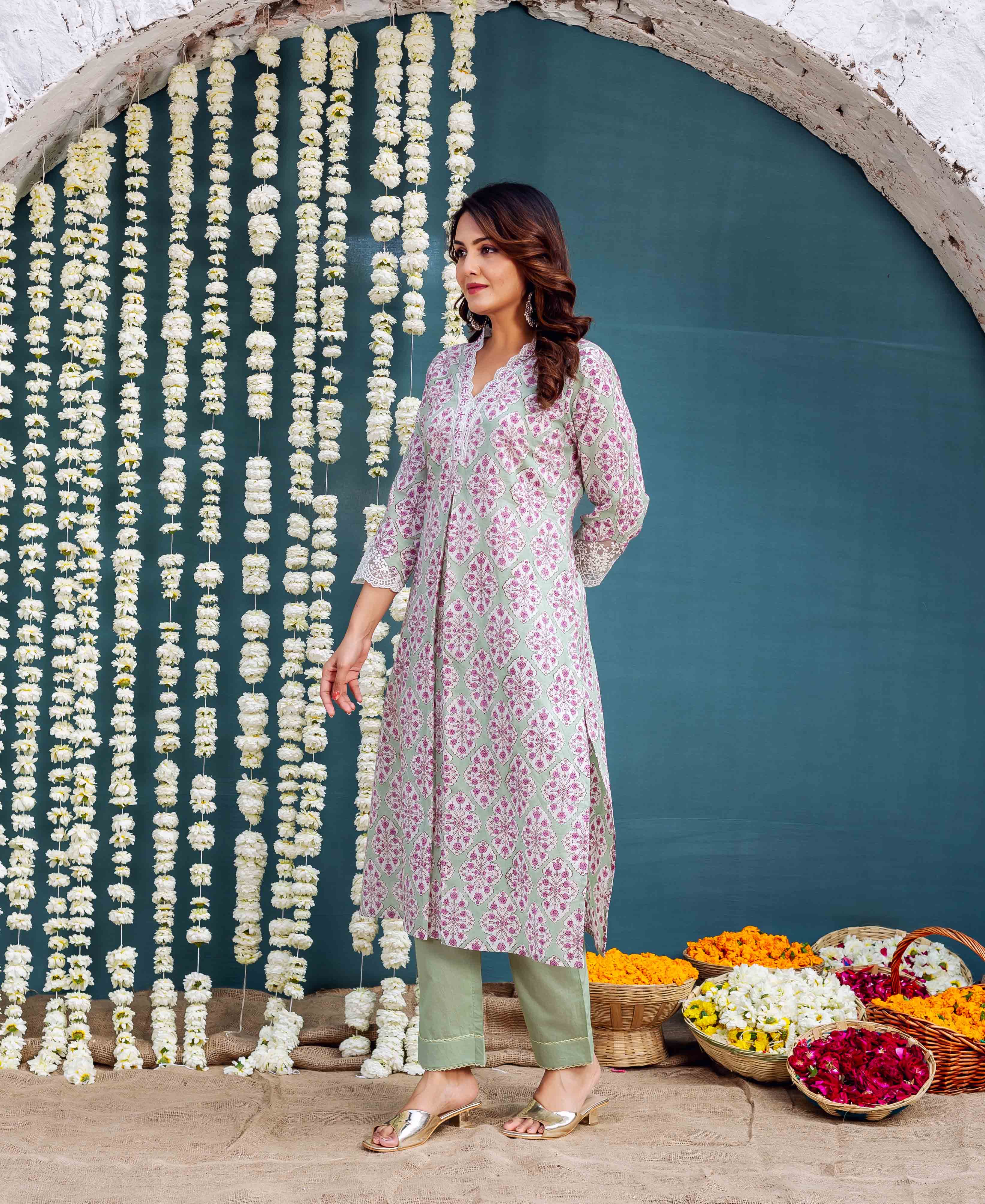 Green hand block printed kurta with pink and white pattern on model, silver heels.