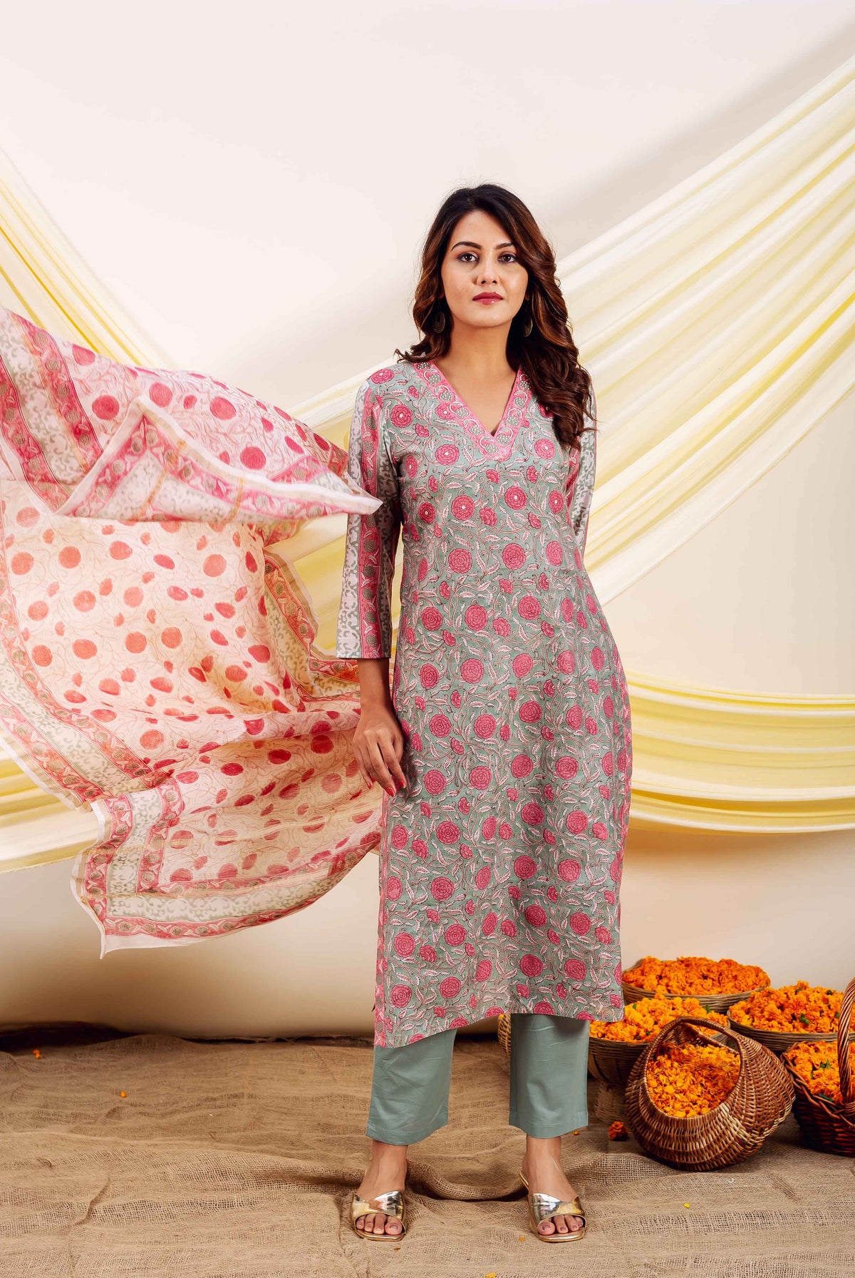 Model wears grey-pink floral block printed kurta, green pants, and flowing polka dot dupatta.