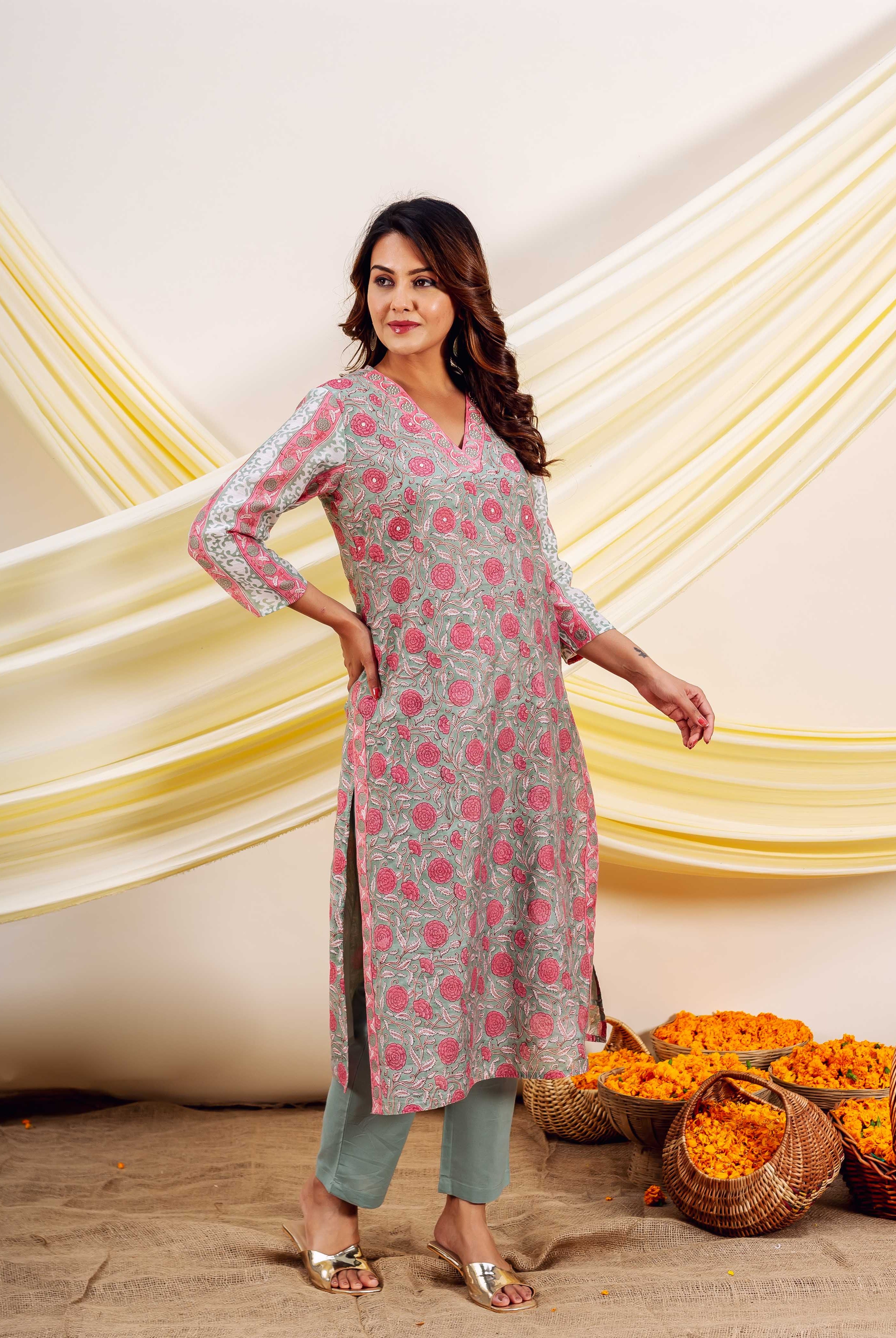 Model wears light green hand-block-printed kurta with pink floral pattern and matching pants.