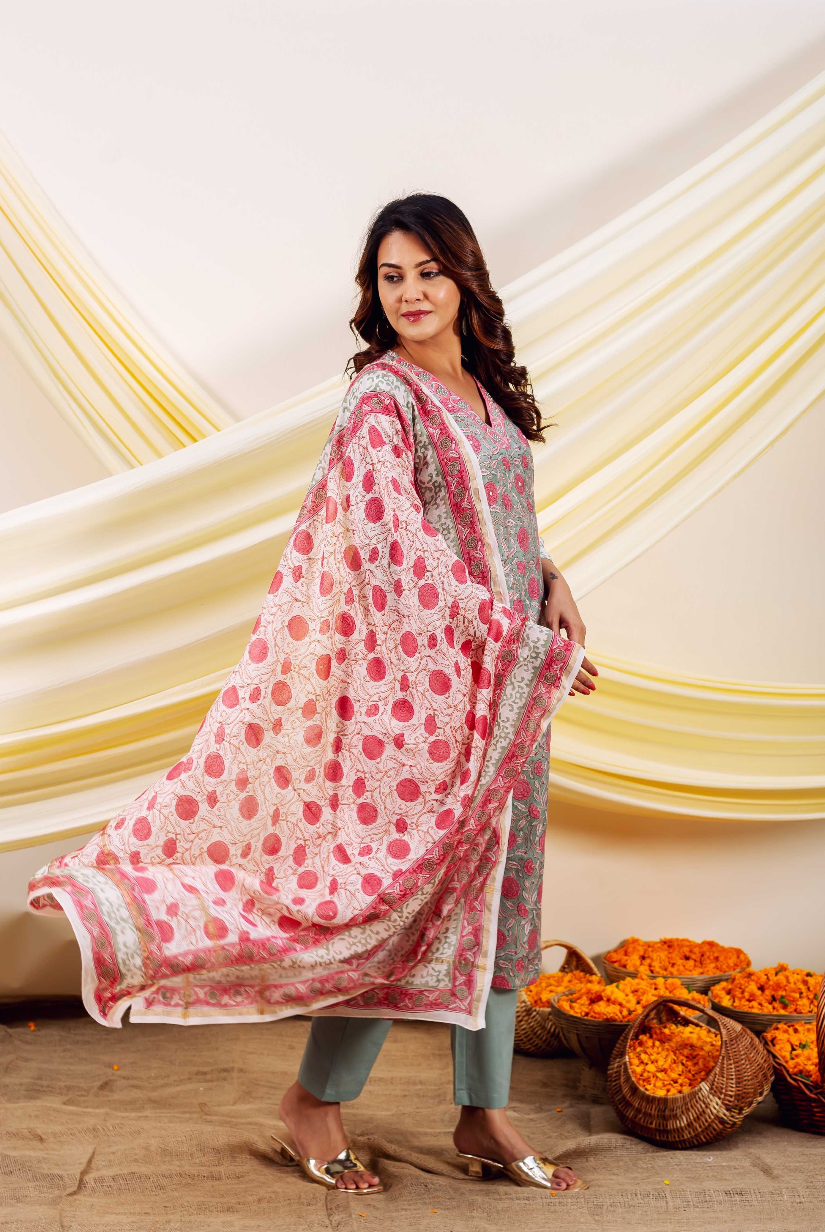 Model in a grey-green block printed kurta with flowing white dupatta featuring pink motifs.