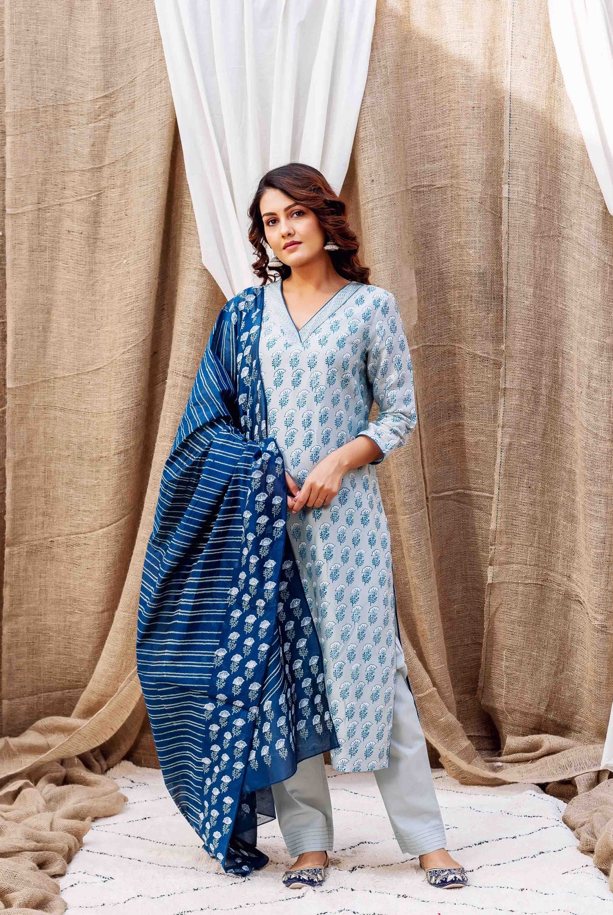 Woman in a pale blue block-printed kurta and pants, with a striped dark blue dupatta.