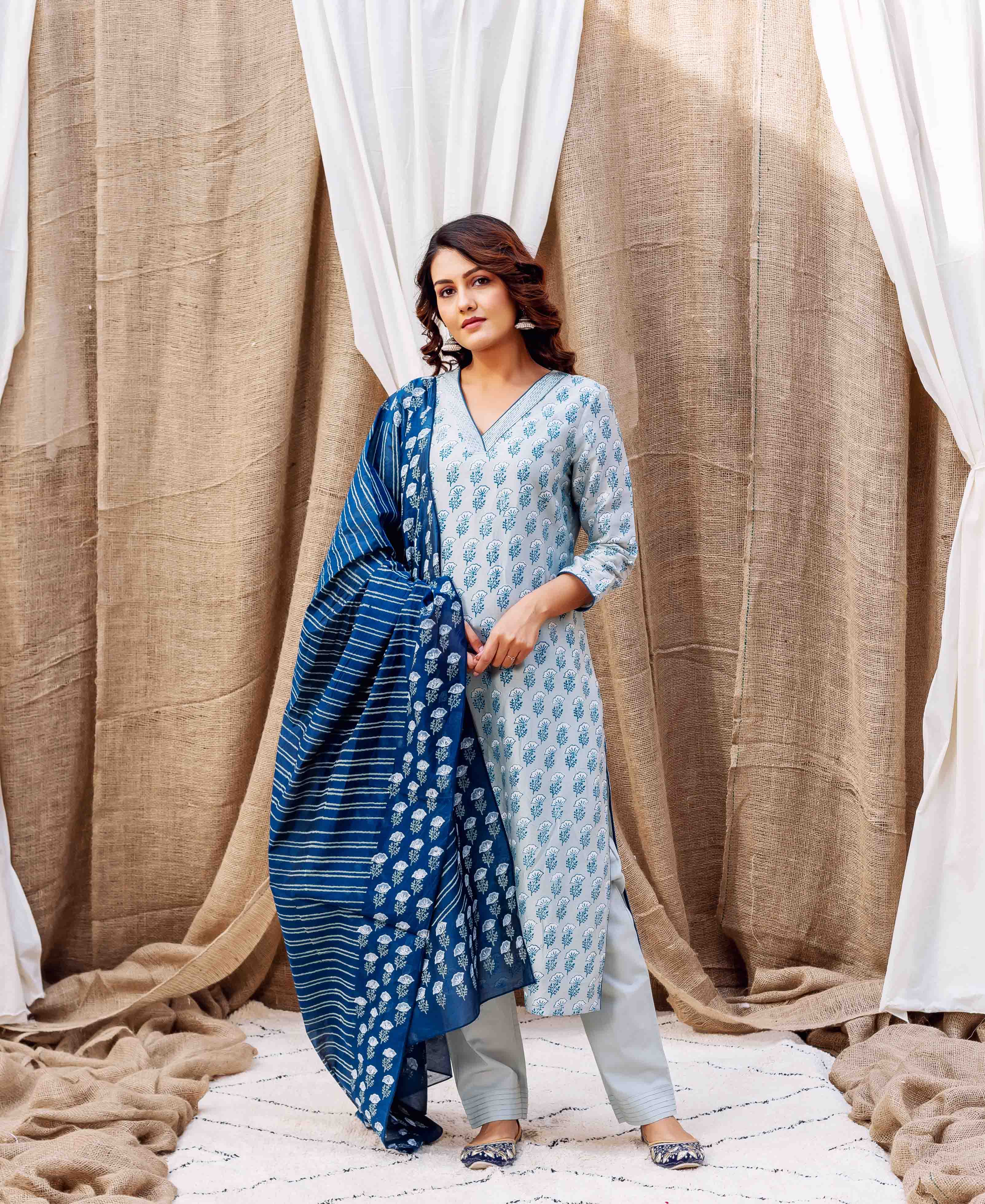 Woman in a pale blue block-printed kurta and pants, with a striped dark blue dupatta.