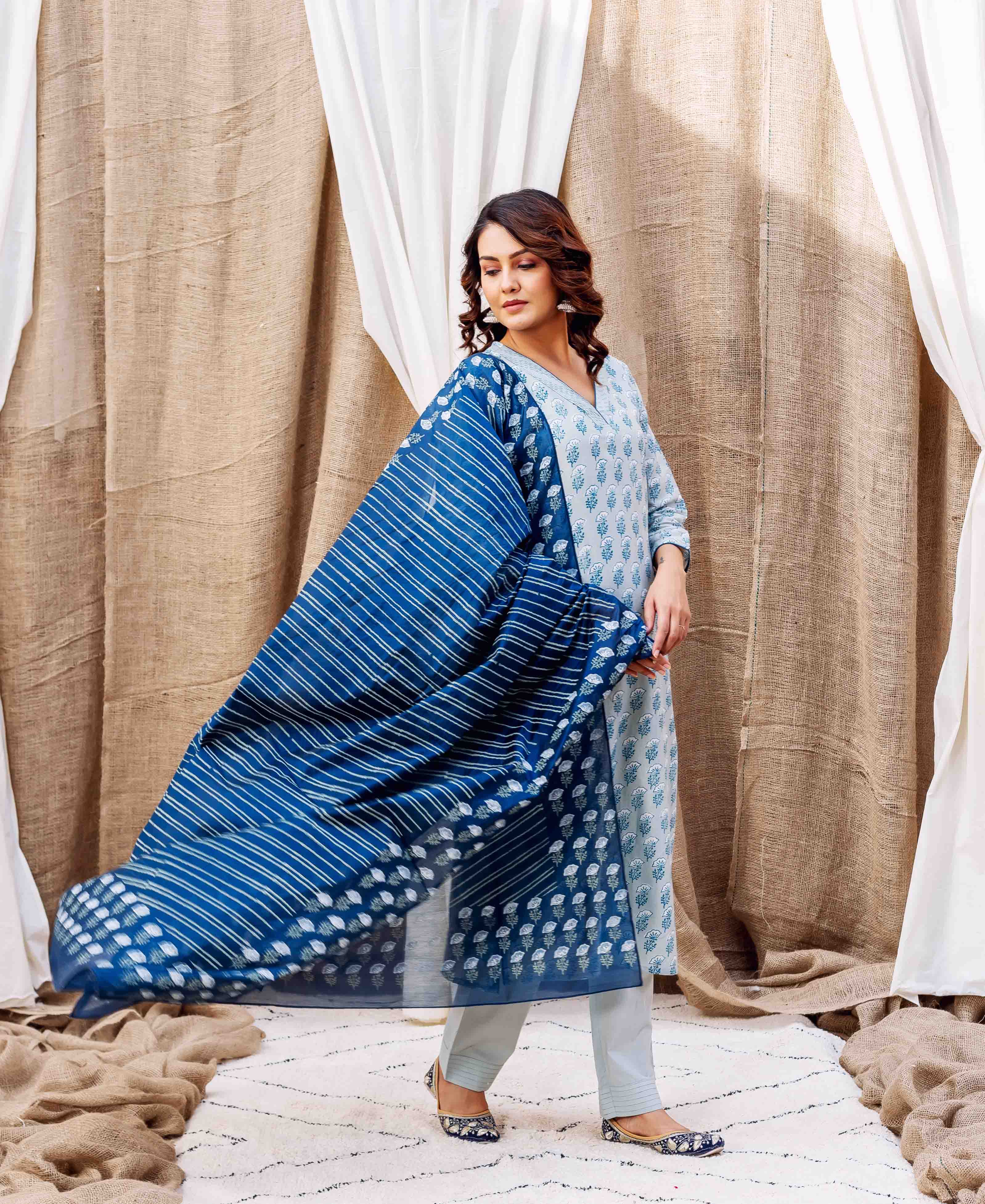 Model in a light blue block-printed kurta with a flowing dark blue striped dupatta, standing.