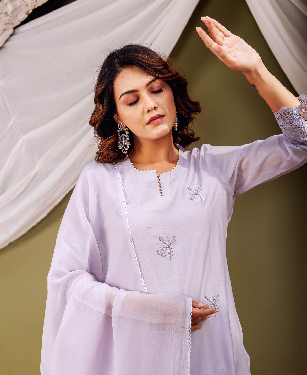 Model wears lavender kurta with delicate grey and pink floral embroidery, white lace trim, and cuffs.