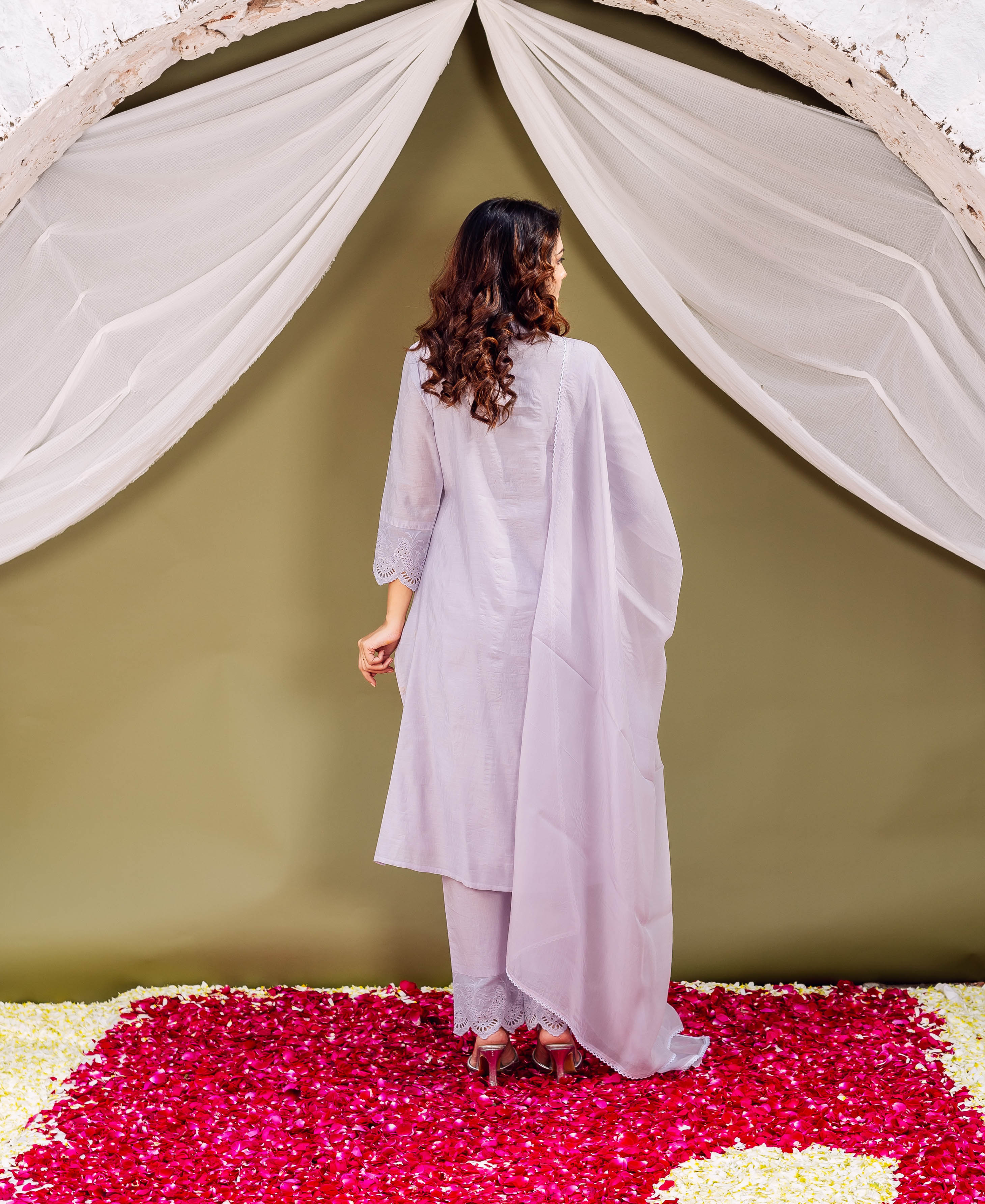 Woman from back in a light lavender kurta set with white cutwork detail.