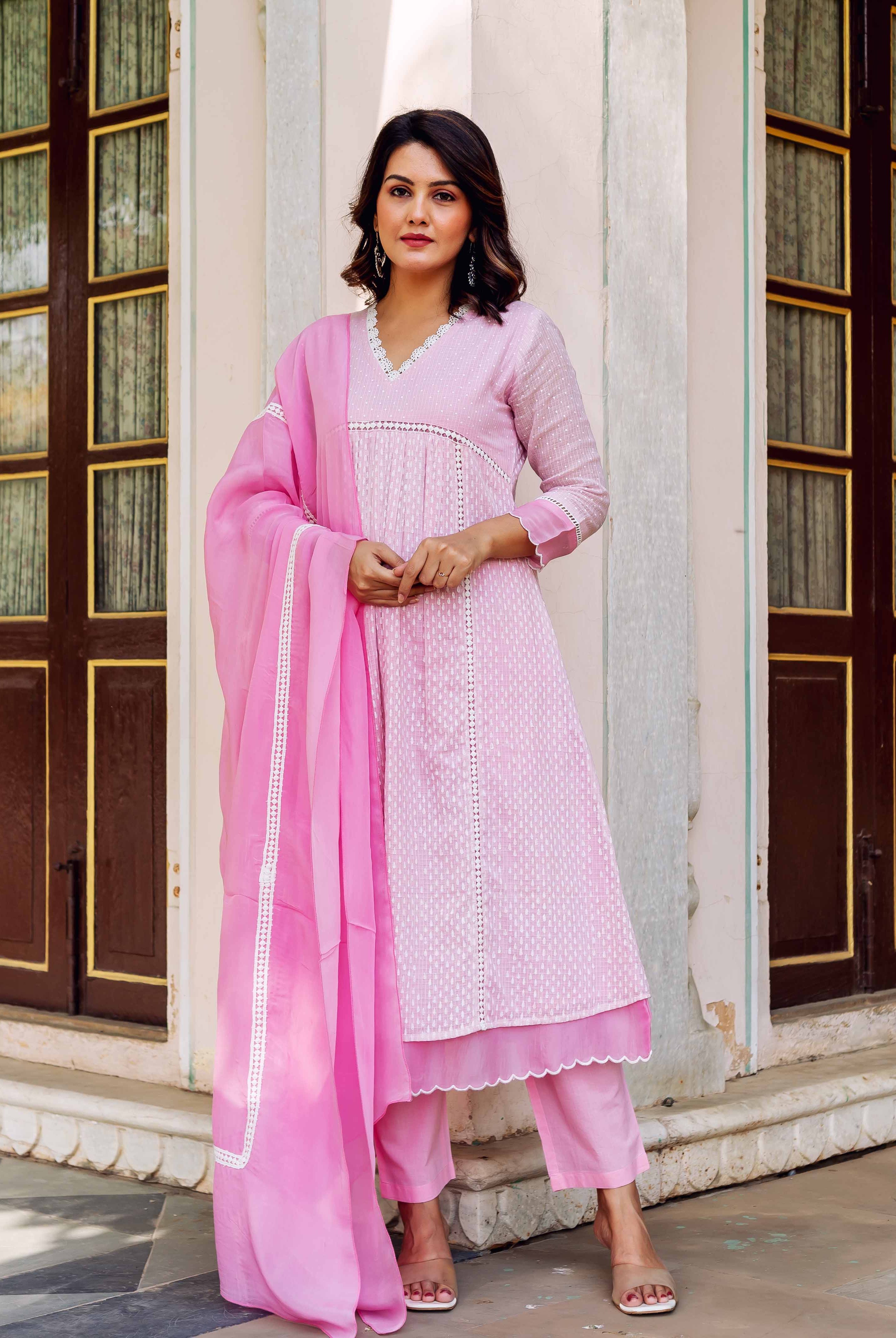 Model in blush pink hand-block printed kurta set with white lace details.