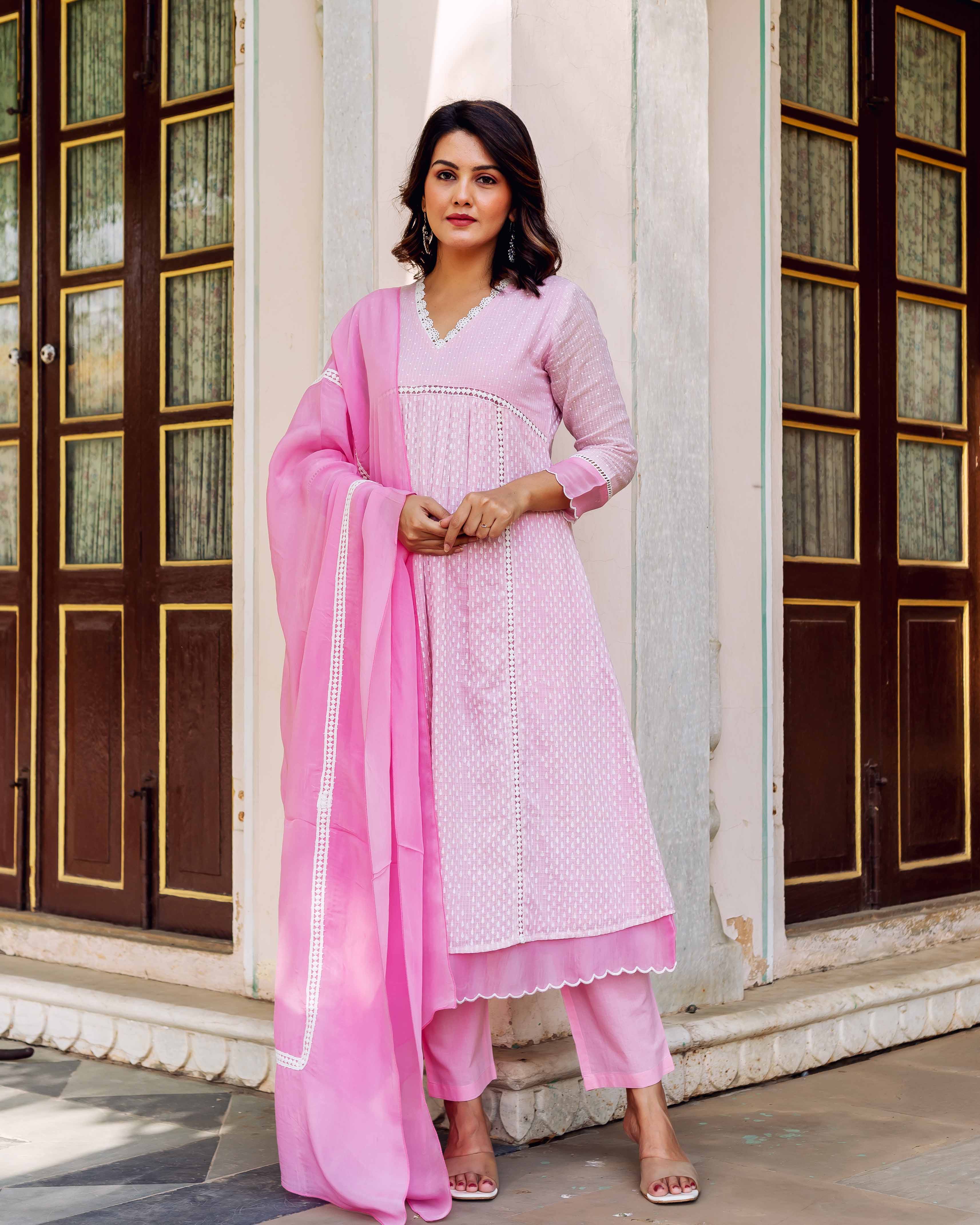 Model in blush pink hand-block printed kurta set with white lace details.