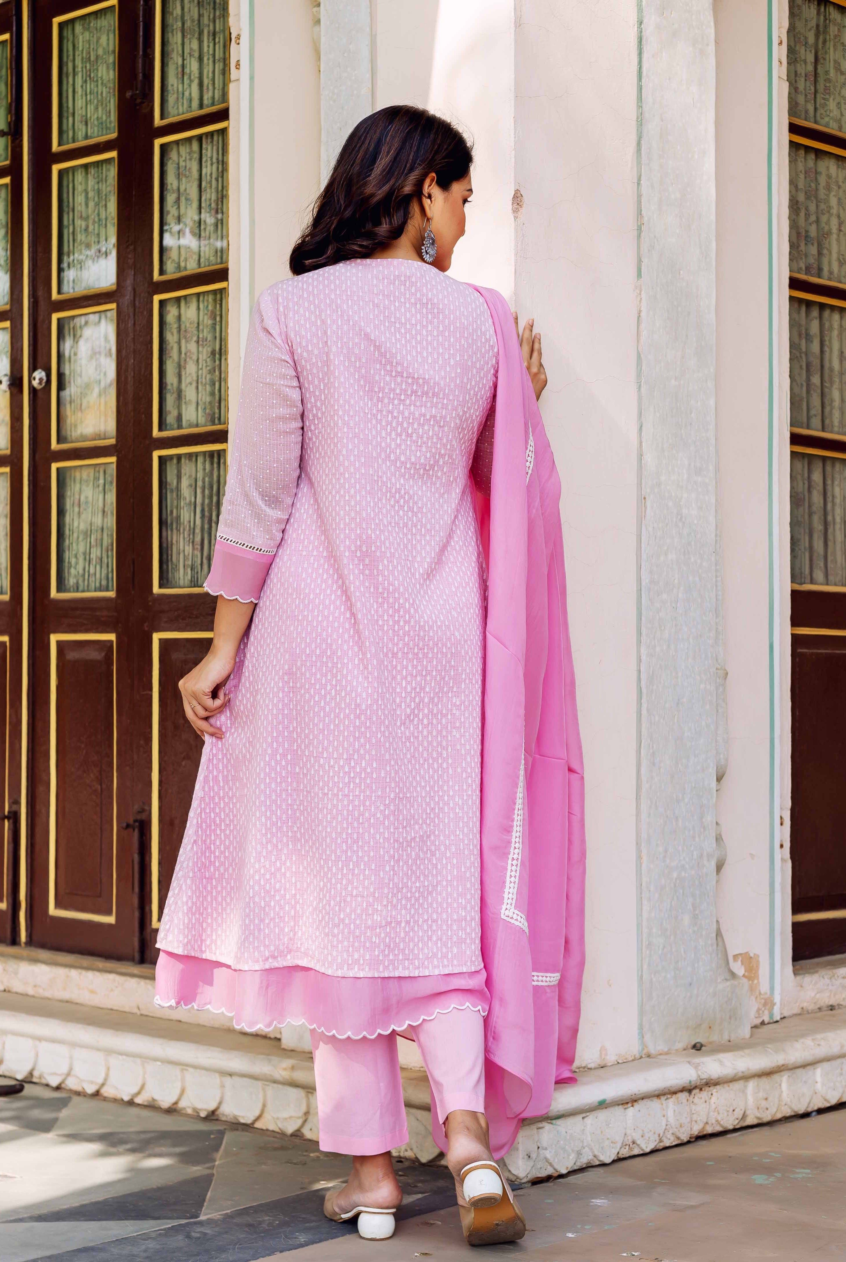 Back view of model in blush hand-block-printed kurta set with white motif print.