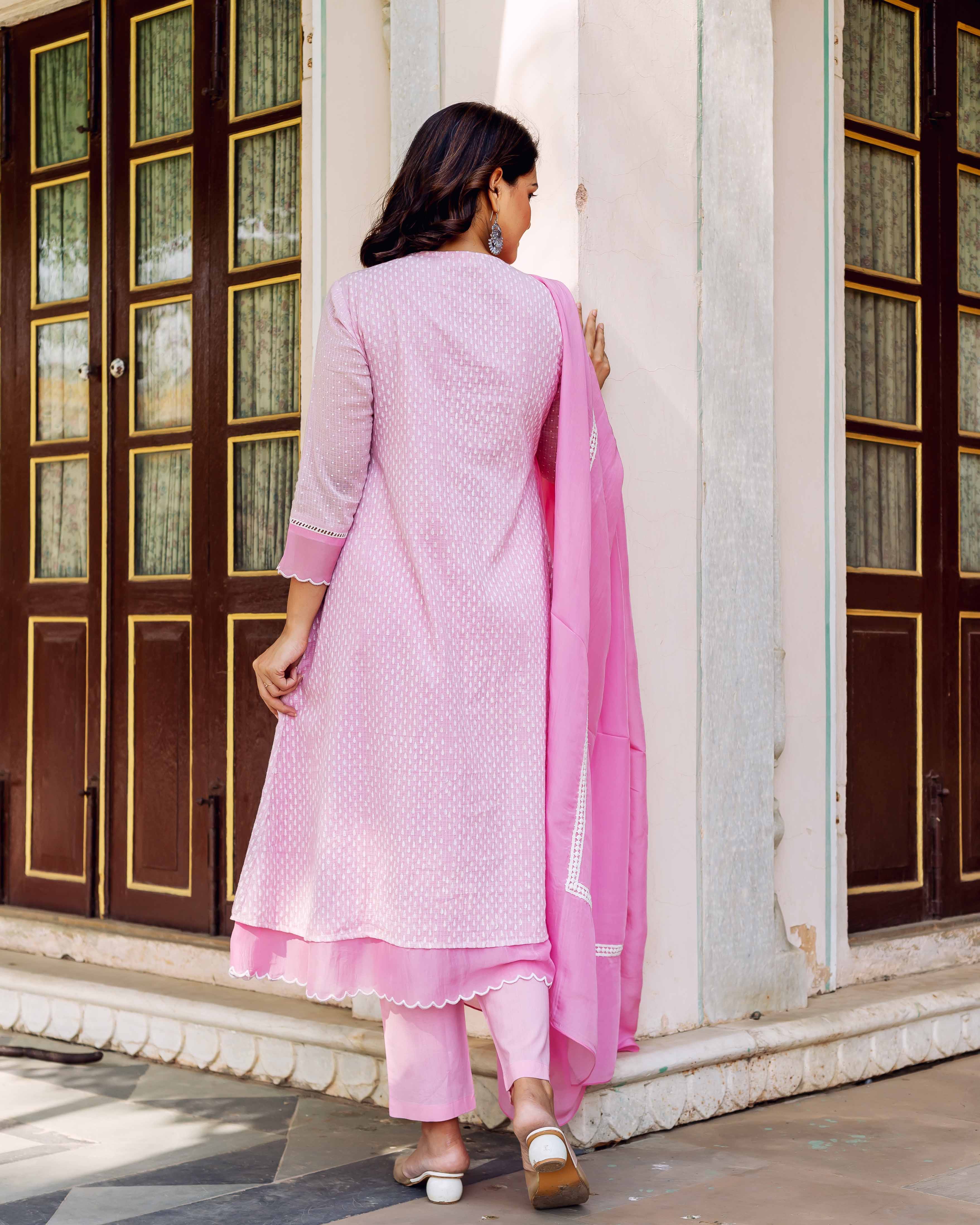 Back view of model in blush hand-block-printed kurta set with white motif print.