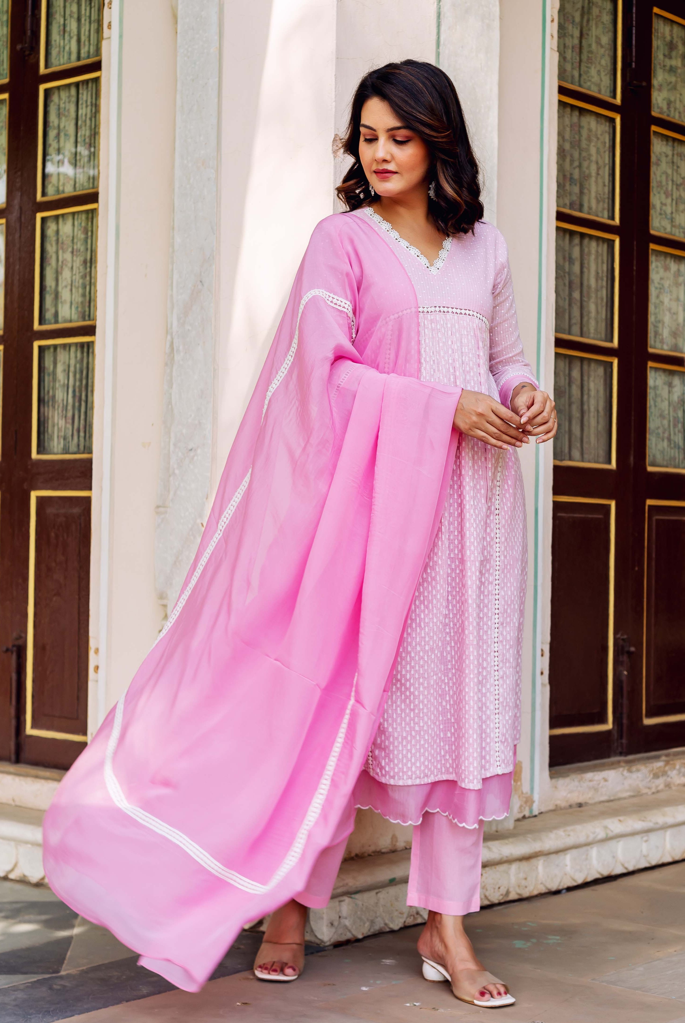 Blush pink V-neck hand-block-printed kurta set with flowing dupatta on model.