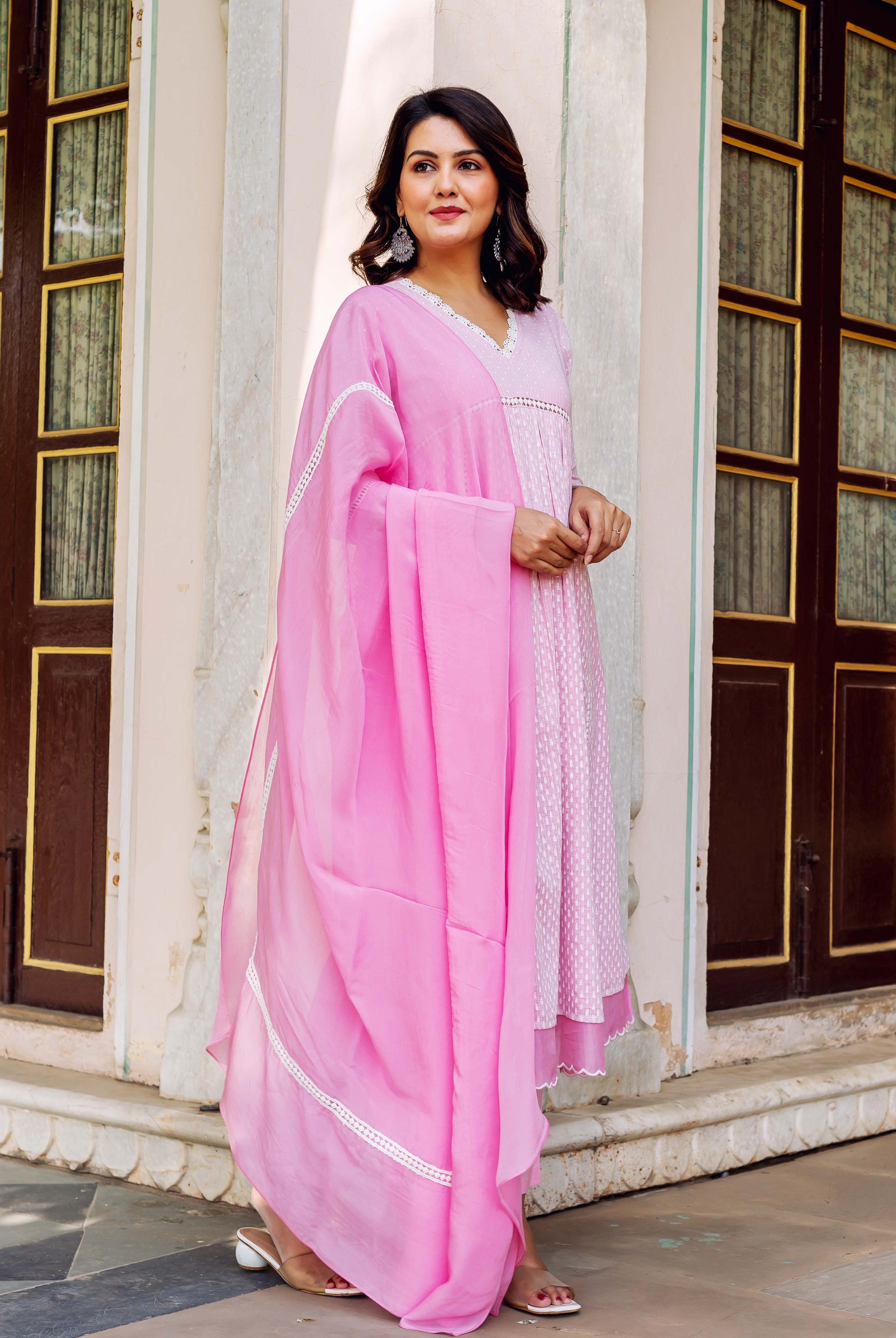 A woman in a pink and white hand-block-printed kurta with a matching dupatta.